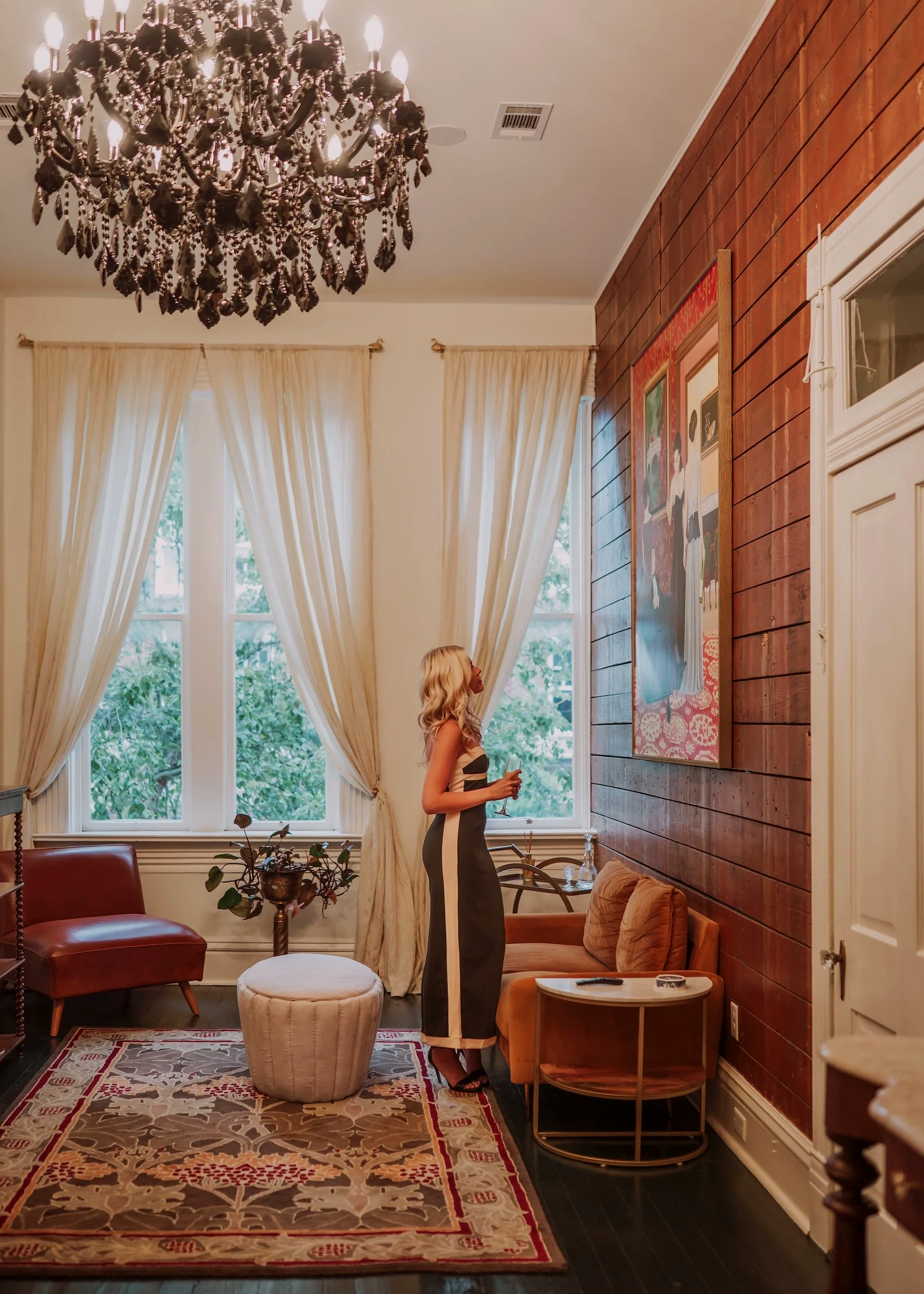 A woman stands, admiring a painting by contemporary Cuban artist Andrés Conde, at the art filled short term rental, Natchez Gallery Suites, above Conde Contemporary art gallery in historic Downtown Natchez, Mississippi.