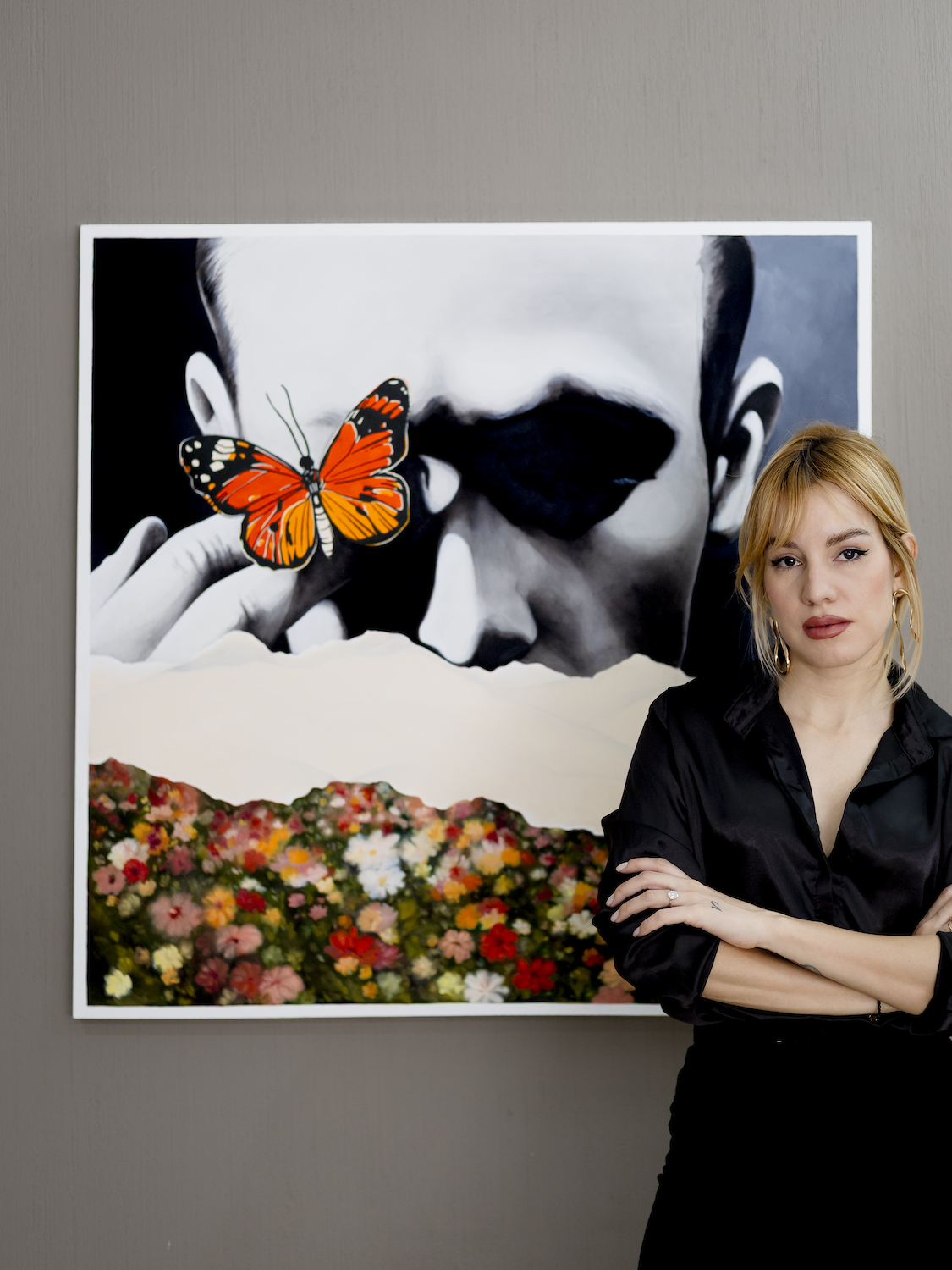 A photograph of contemporary Cuban artist Wanda Fraga Sánchez de la Campa in front of her painting titled What Was Left Behind, represented by Conde Contemporary.