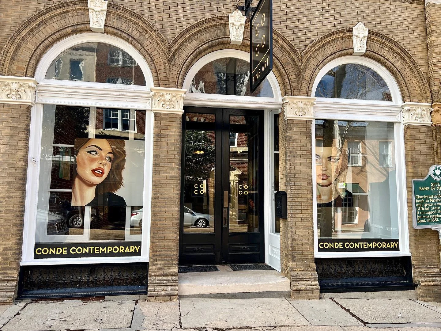 The front of Conde Contemporary art gallery in Natchez featuring works by Andrés Conde in the windows.