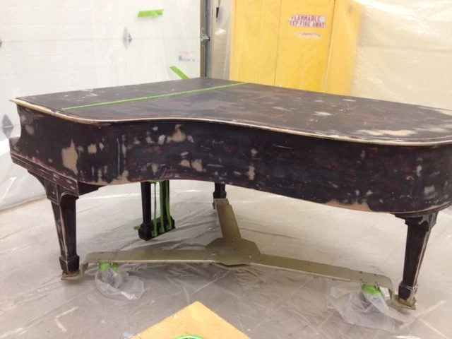Filling the dents on an abused piano.