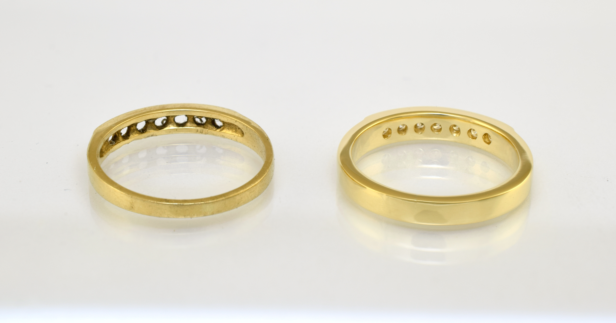 Metal under the diamonds of the old and new rings respectively.