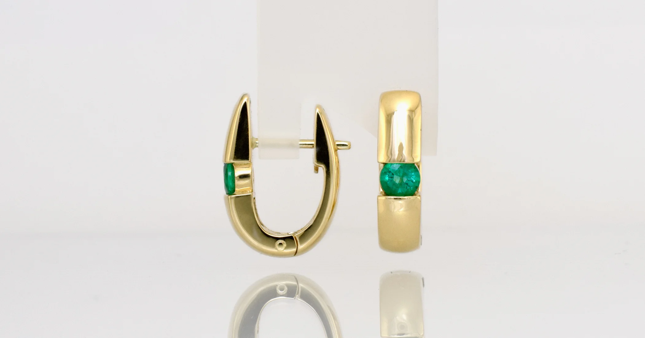 Natural Emeralds set in 18ct yellow gold clip hoop earrings.