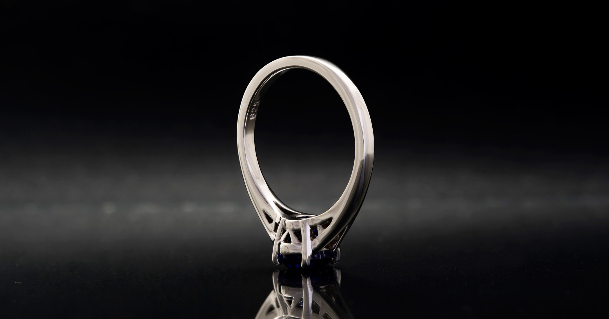 The gem is set as low as possible with the culet (bottom point) of the gem almost down on the finger.