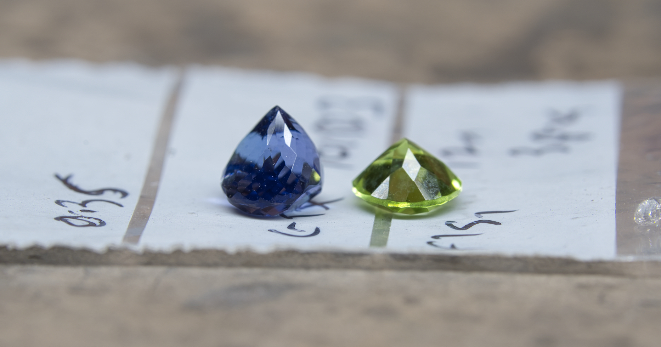  A conventionally cut peridot next to the “Jungle cut” Tanzanite. 