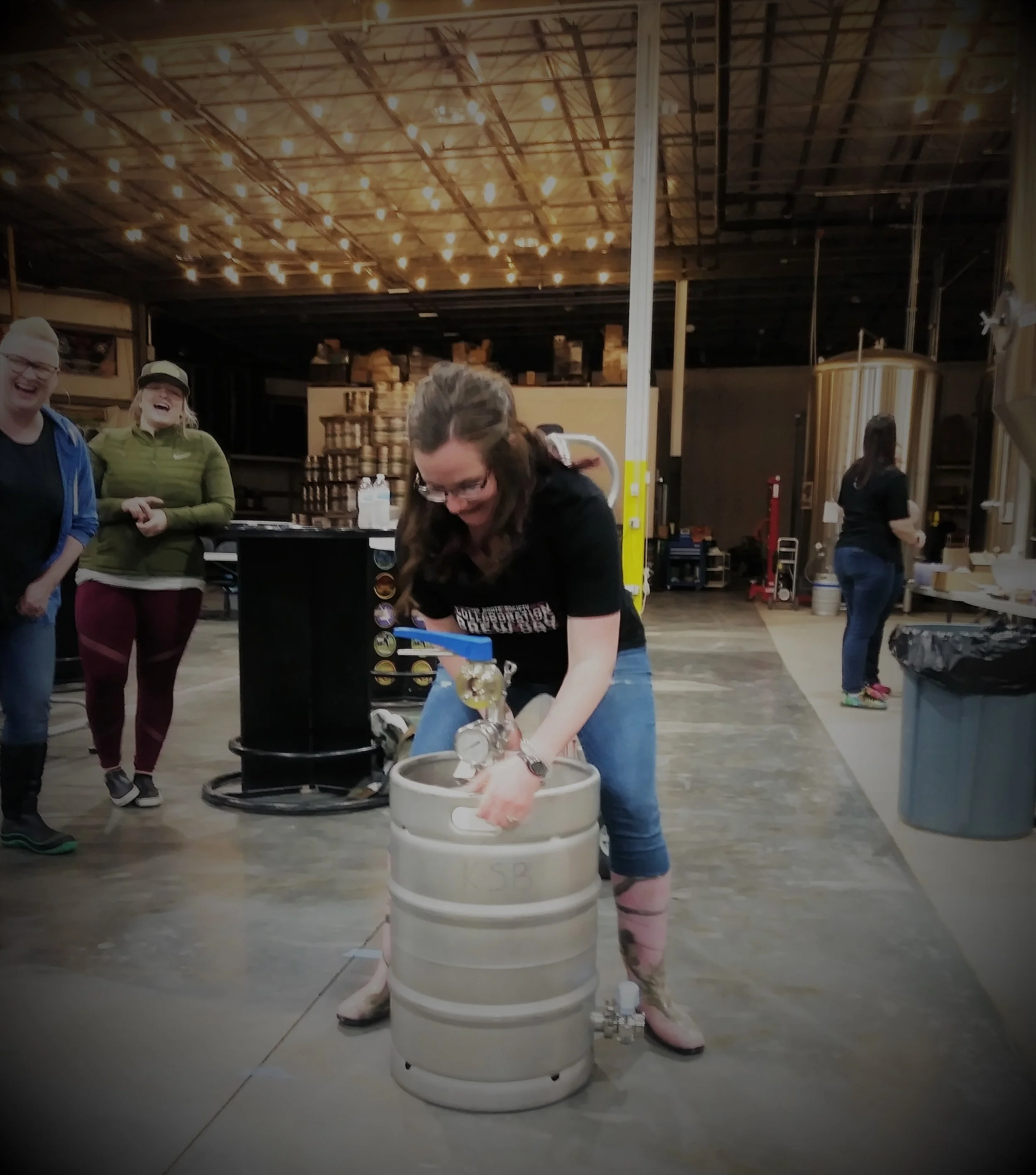 Kim is taking her turn mixing the yeast in the keg