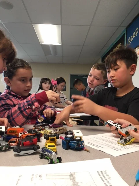 can you build a bridge using popsicle sticks and tape that will hold the weight of all these toy cars?