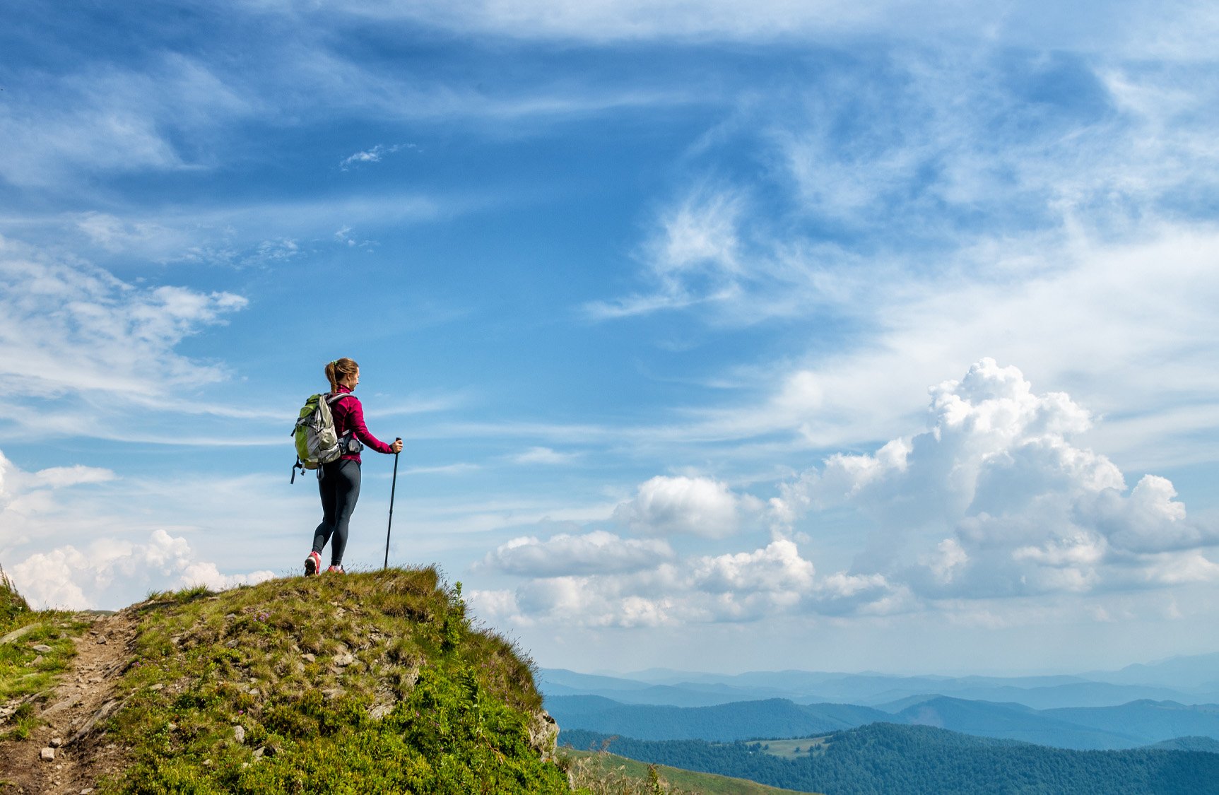 Hiker standing on a hill overlooking the mountains