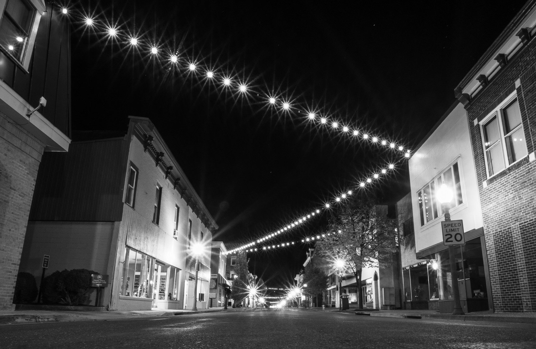 Historic Main Street in Front Royal Virginia at night with string lights and storefronts