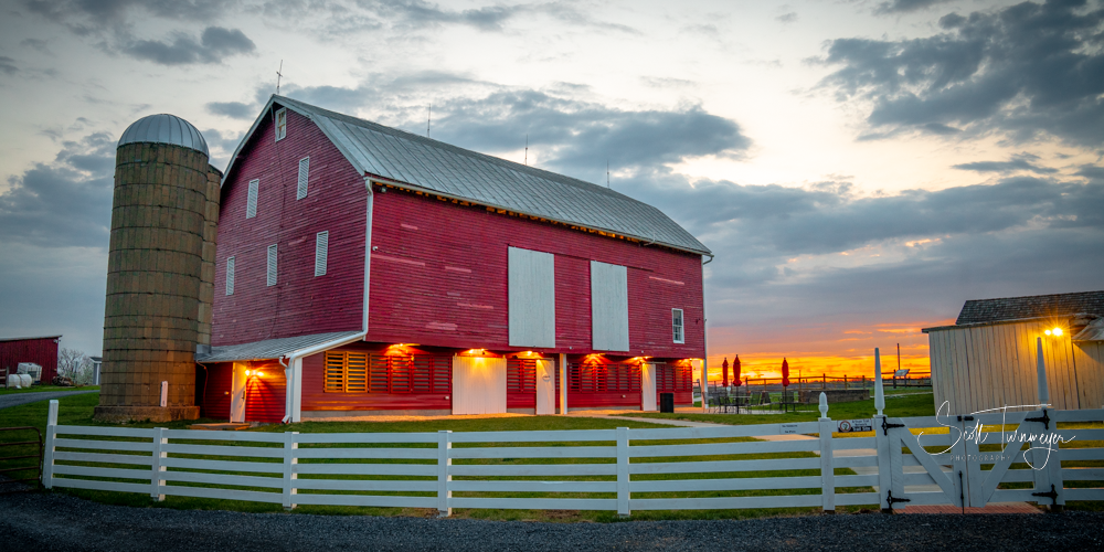 Rural farm scene in Warren County Virginia with red barn and sunset sky