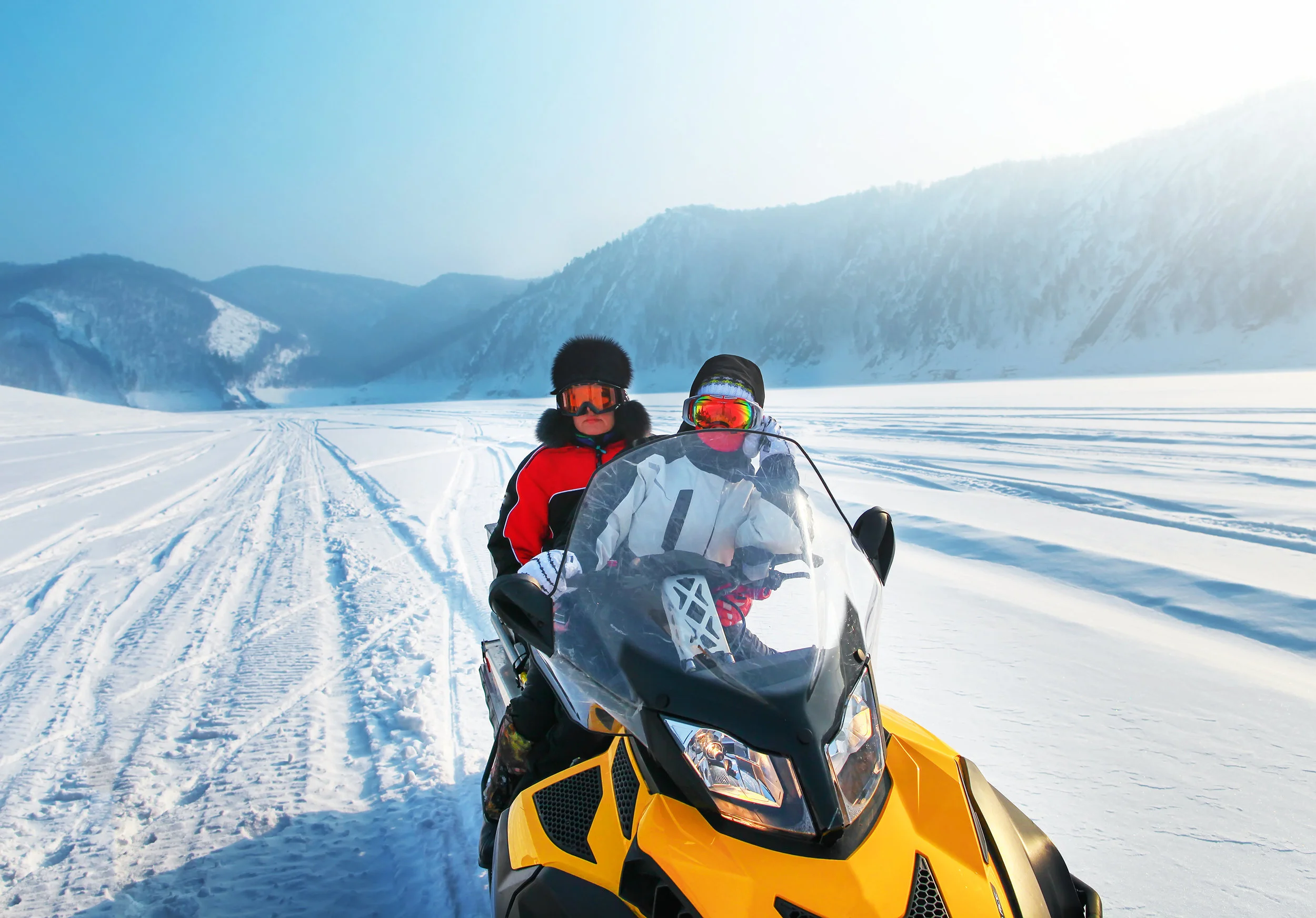 Man and woman riding on snowmobile