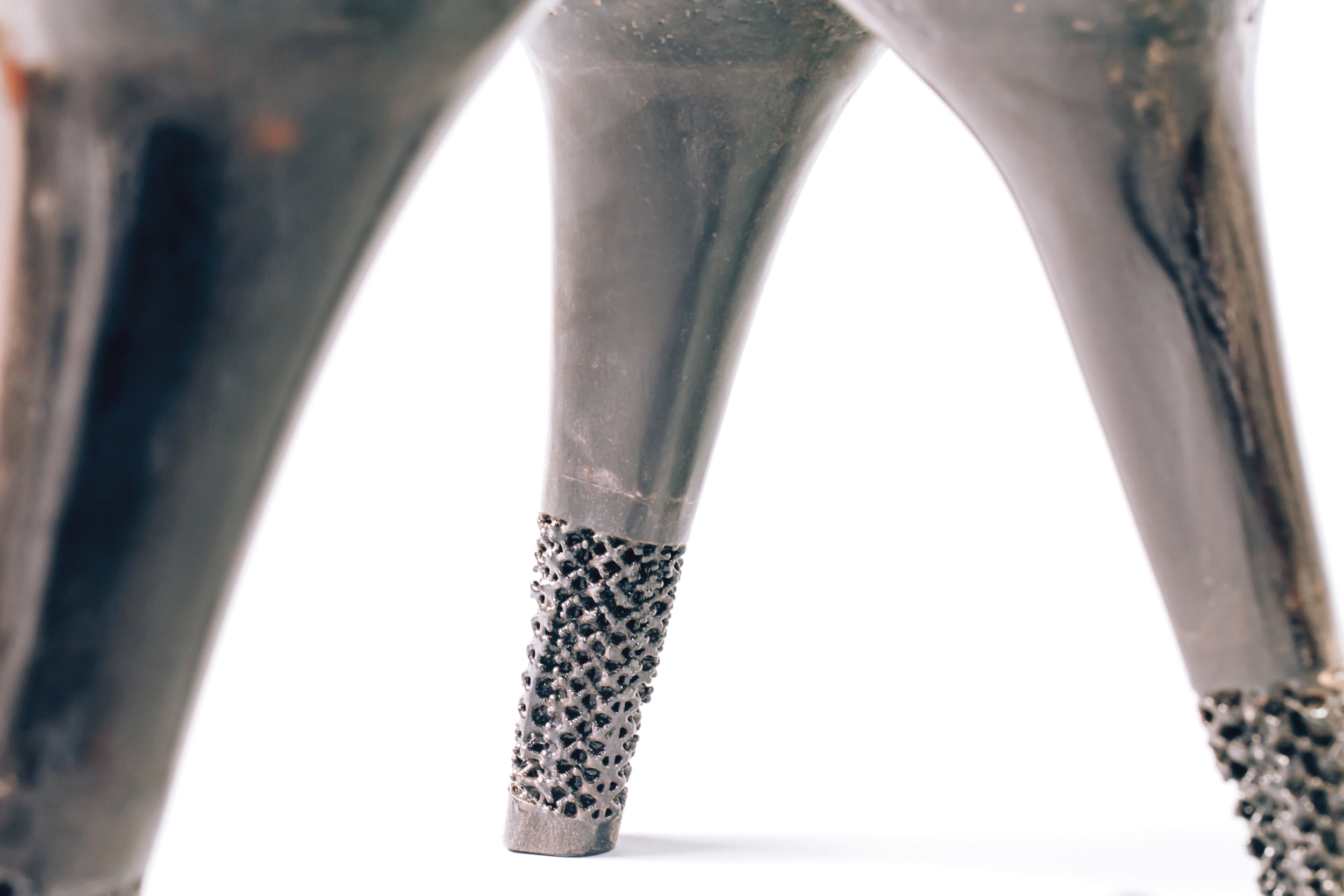 The underside was then milled in preparation to assemble and insert the 3D printed legs. Each 3D printed leg while apearing as a massive forms, are in fact hollow shells comprised of two seperate pieces. The bottom portion of the leg was further revealed, where it meets the ground, to show the complex hollow structure within.