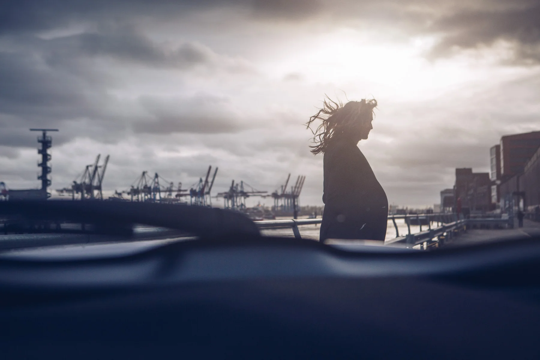 ©TomWoollard_Toyota_C-HR_road-trip-woman-silhouette-at-hamburg-docks-dramatic-sky-editorial.jpg