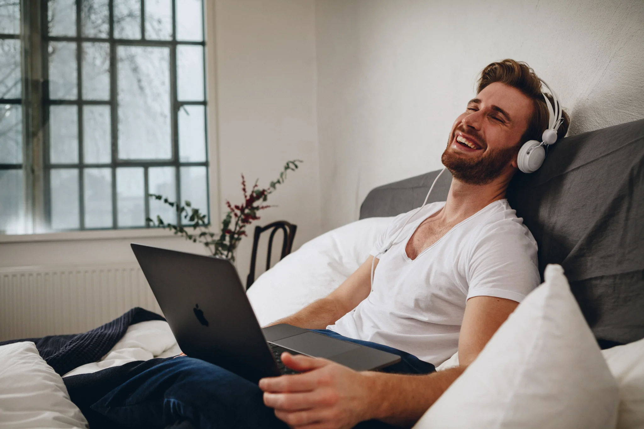 ©TomWoollard_NiveaMen_editorial-lifestyle-handsome-stylish-man-in-bed-laughing-headphones-on-laptop.jpg