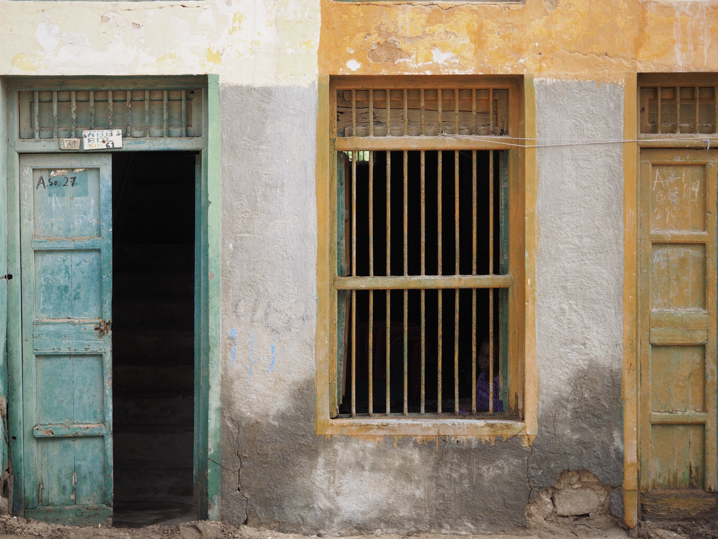 A child keeps a safe distance behind bars in Berbera.