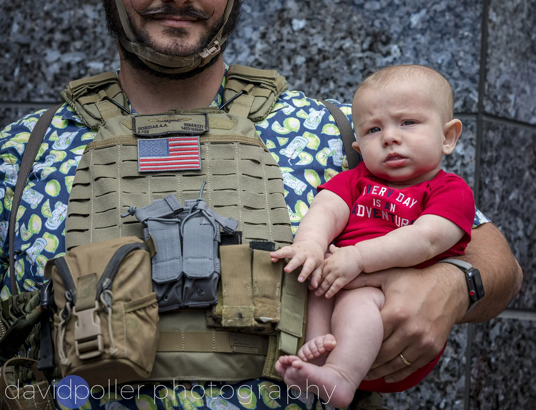  Wearing military gear over a Hawaiian shirt, Aaron Gobidas of San Diego holds his son Gaius Atlas Gobidas, 5 months old and wearing an "Every Day Is An Adventure" onesie. They were at a "Liberate San Diego" rally on Saturday as protesters waved sign