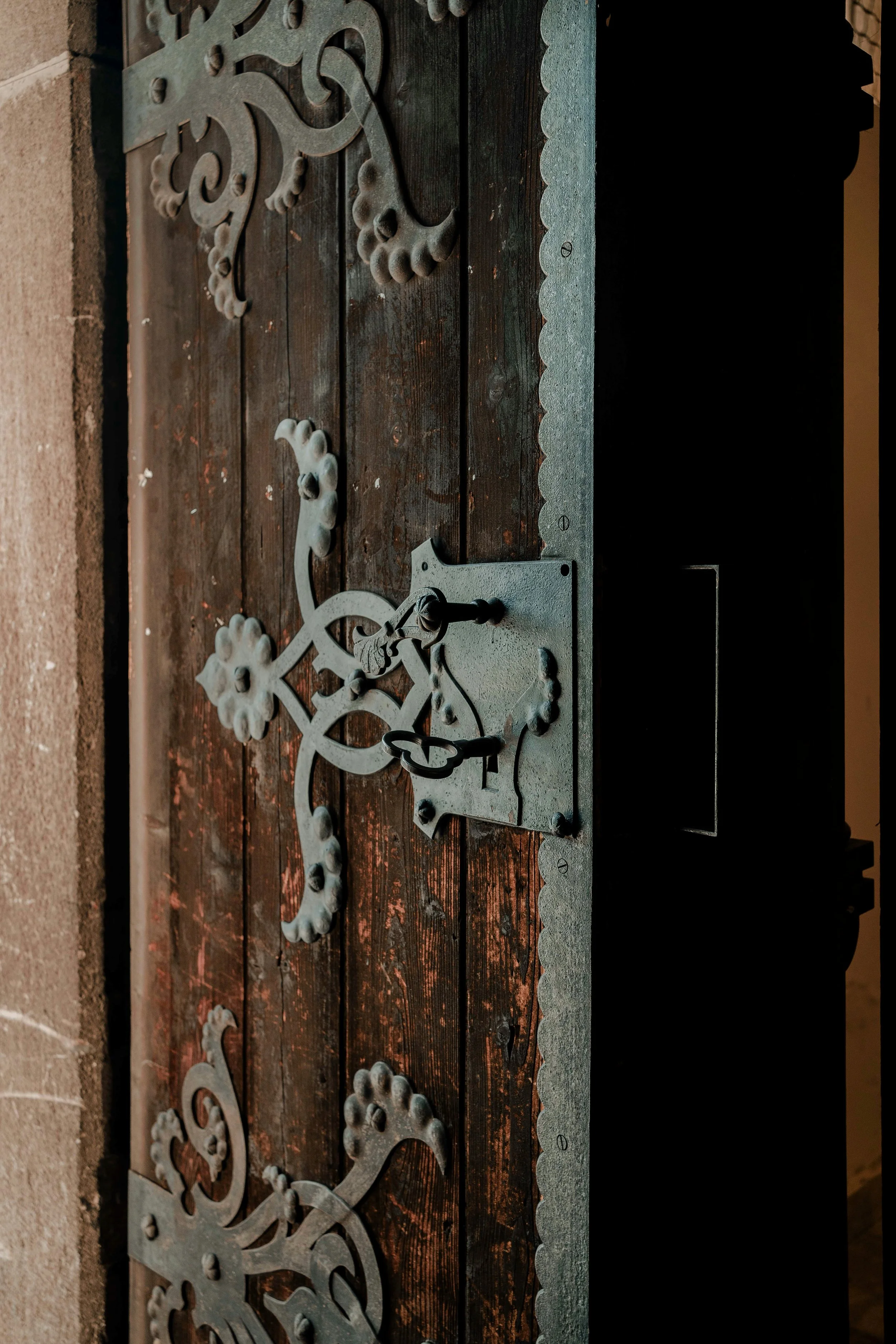 Decorative metalwork pieces placed on a wooden surface, with a measuring scale at the bottom right.