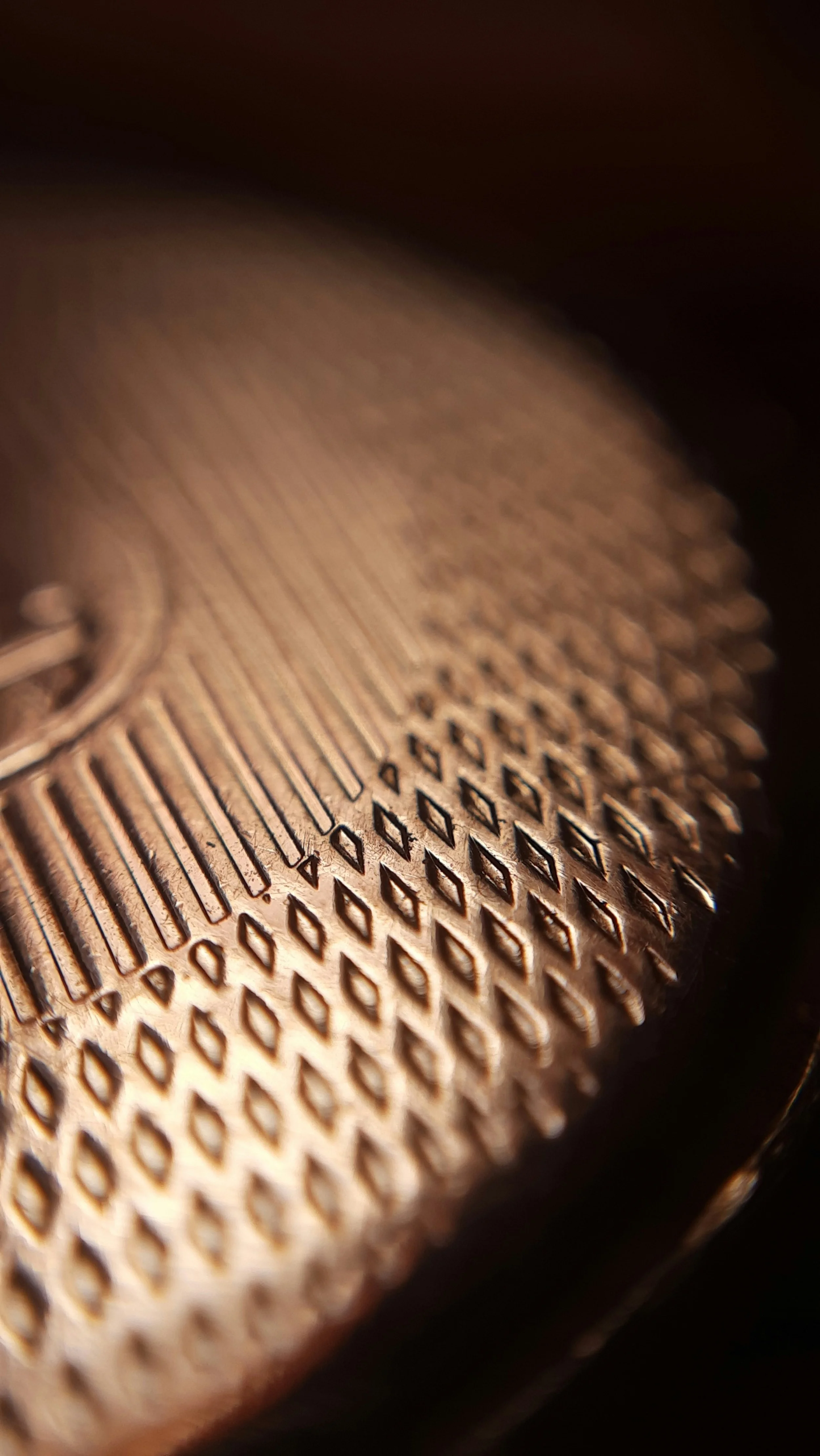Close-up of a cast iron surface with a detailed pattern of geometric indentations and lines.