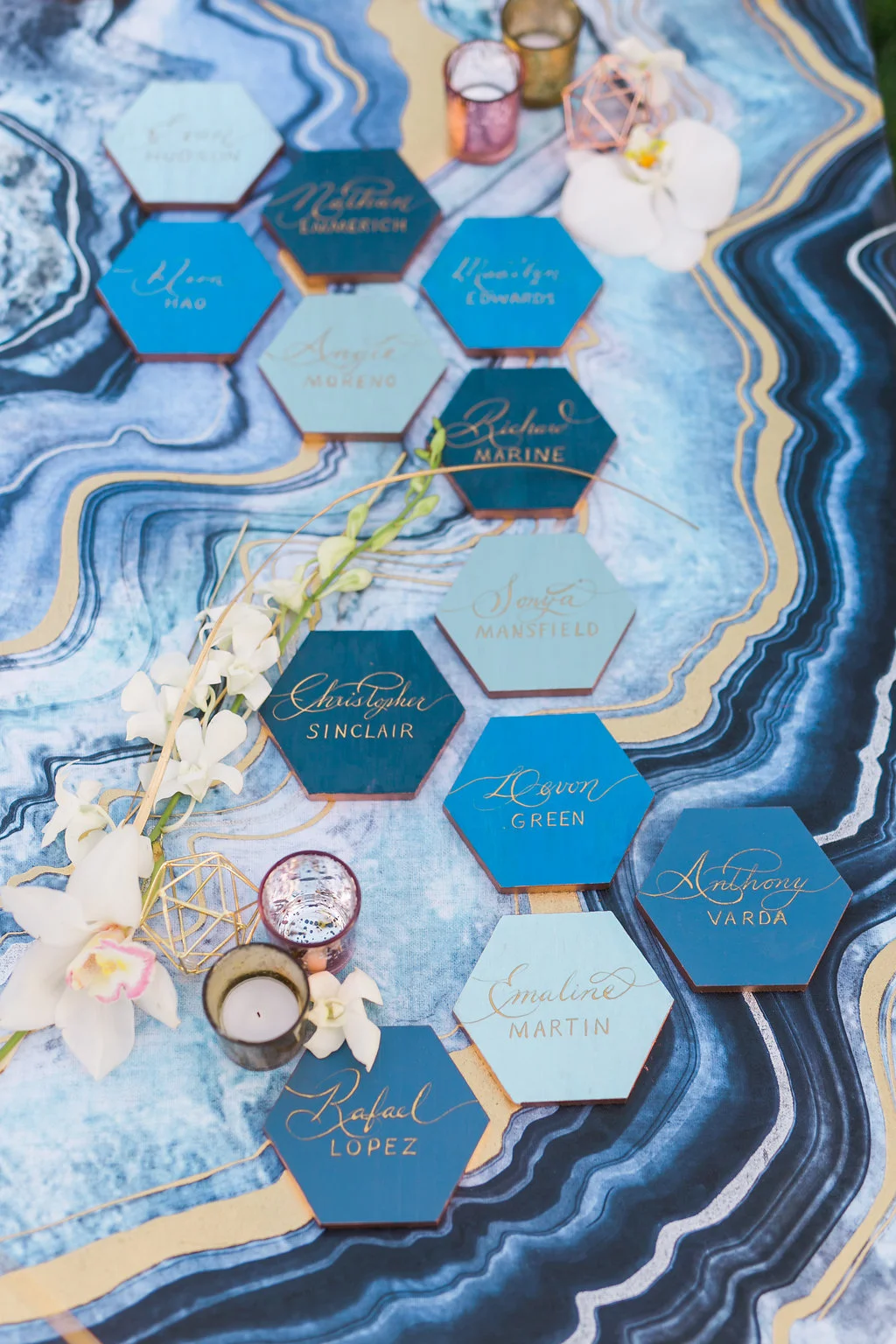 The escort cards were a favorite project and started with gray hexagon tiles that I painted in different shades of blue and gold paint around the edge. The look was completed with beautiful hand painted calligraphy by Olivia of Handcrafted Occasions with a marble like blue and gold canvas painting as a backdrop.