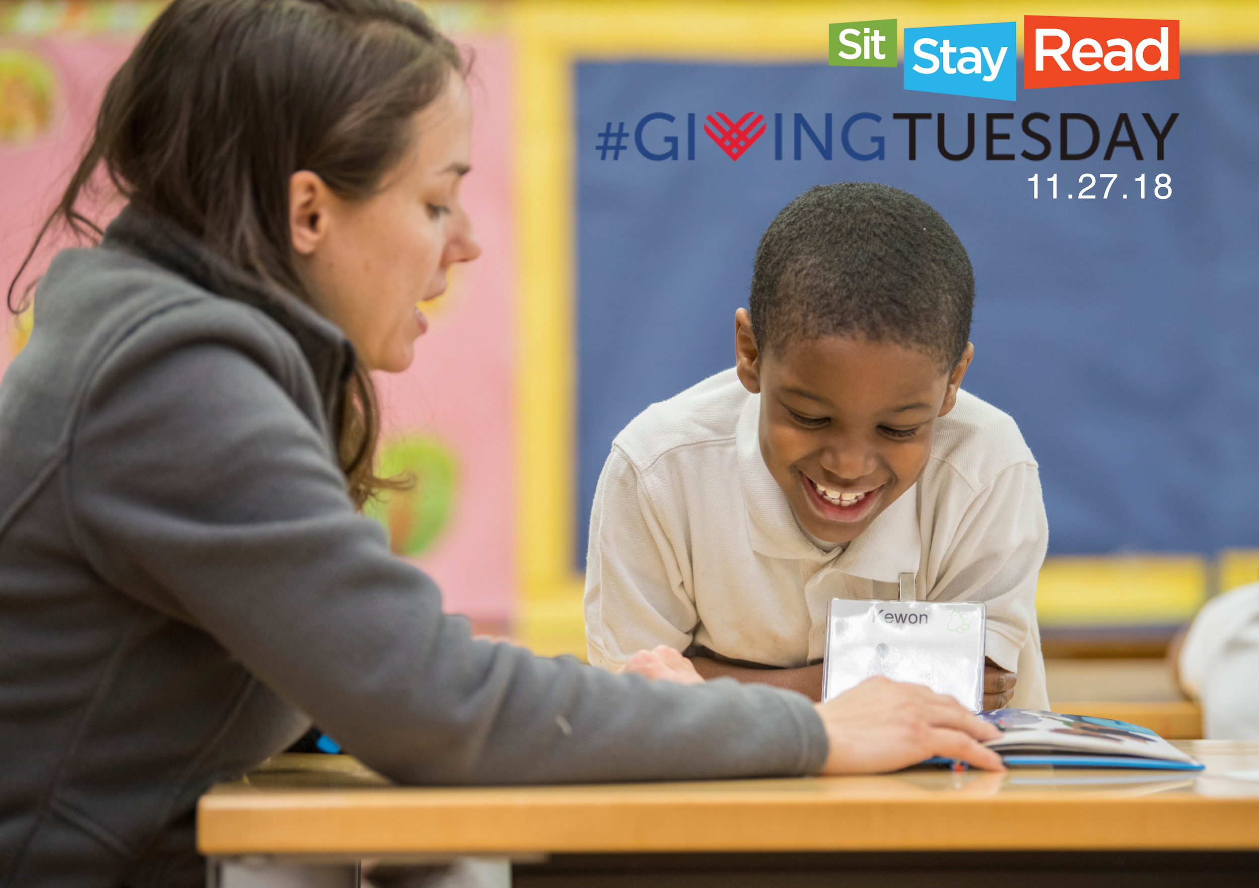 SitStayRead Program Director, Kate, works with second-grade student Kewon on his reading skills. (J. Sall)