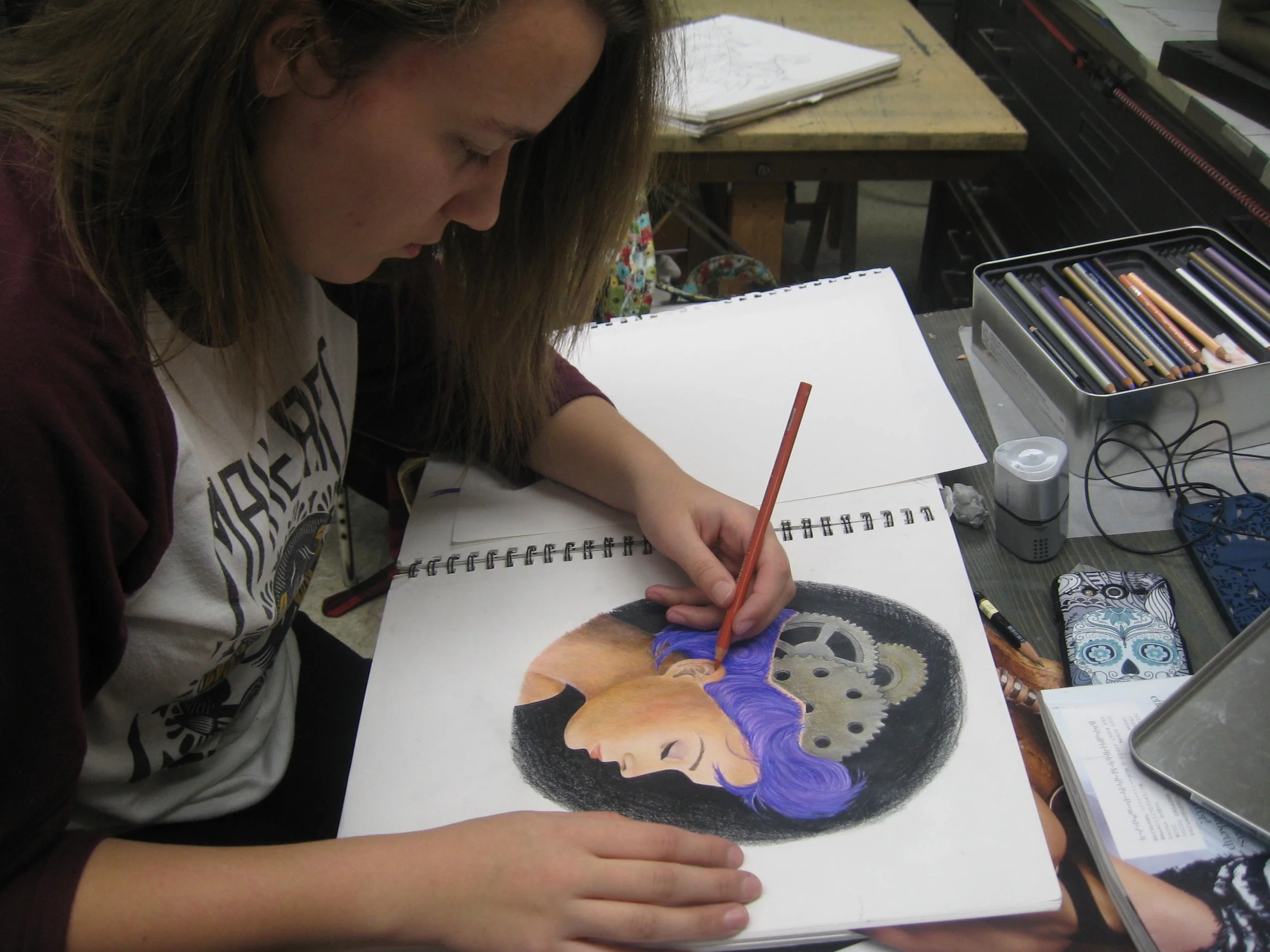 Karoline working in Prismacolor pencils on drawing she created in Open Workshop.