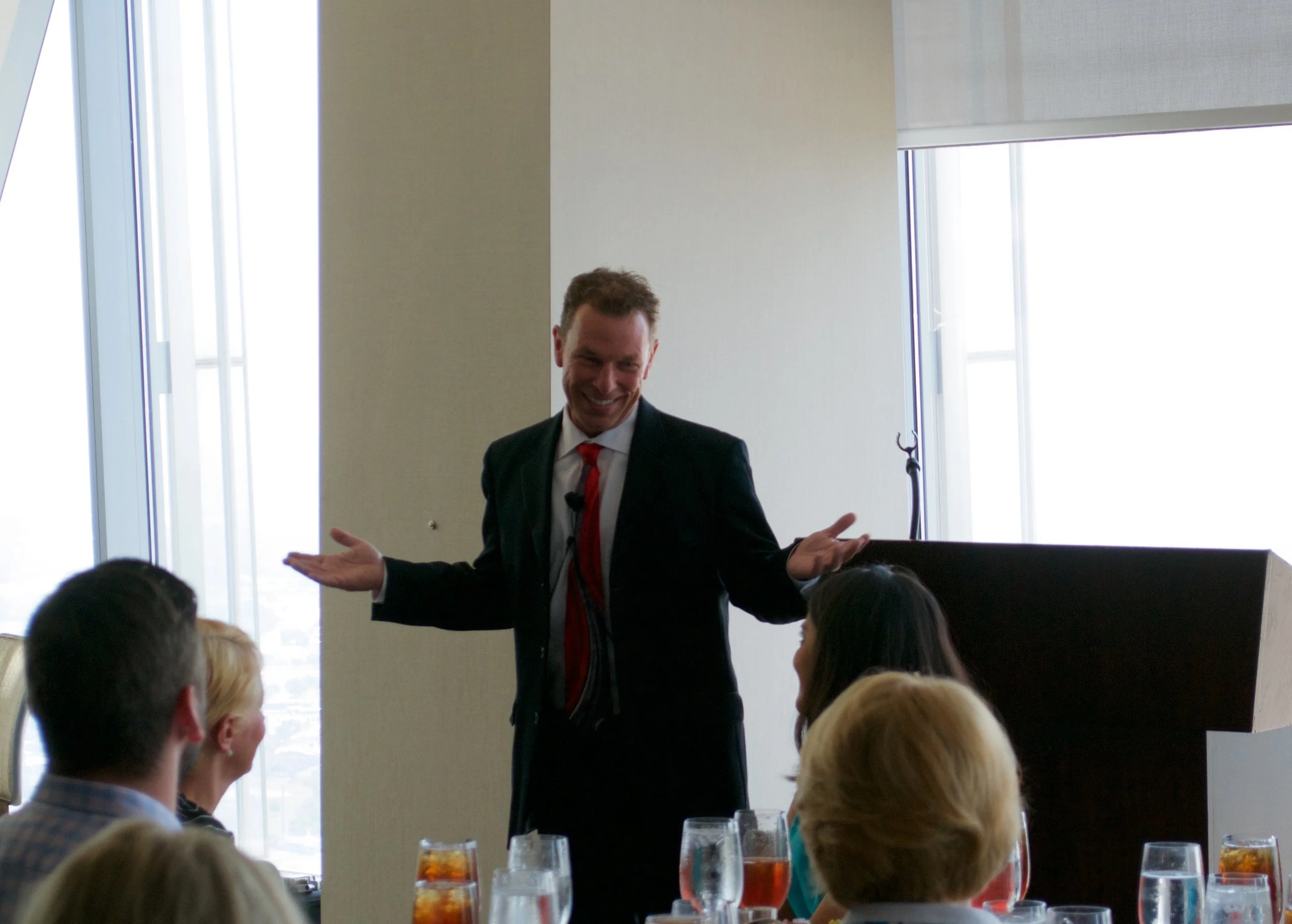Michael D. Morrison presenting to a seated audience at a business luncheon