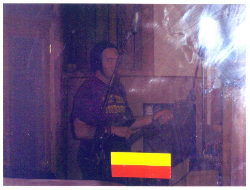 Ghost in the Machine The famous photo of the ghost. Here the bassist from Drown Mary is visited during a recording session in the live room. The yellow and red stripes on the bottom of the shot are taped markers on the glass door through which the photo is taken.