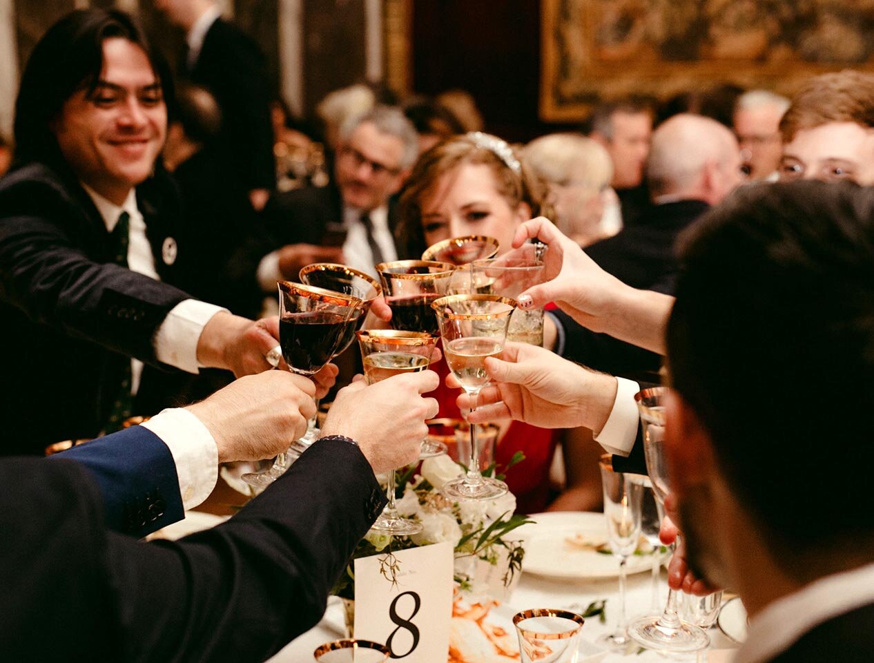 Wedding guests raise their glasses in a toast.
