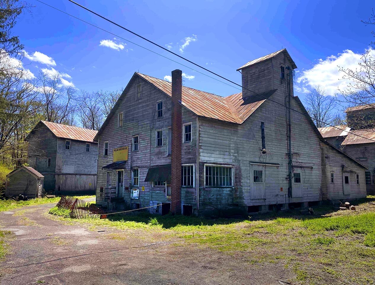 Exterior view of a wooden-sided barn building. It is part of the Anderson feed mill complex in Accord, New York.