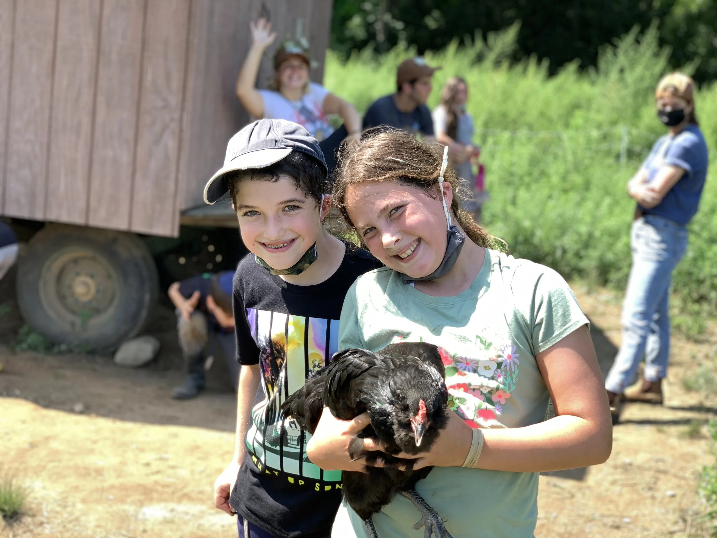  Two smiling children, one holding a rooster 