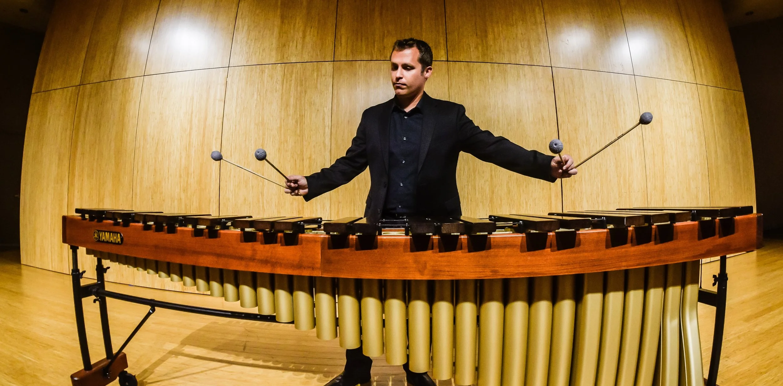 Percussionist Christopher Whyte has emerged as one of the Pacific Northwest’s most engaging performers and educators. He is currently Acting Head of Percussion Studies at Portland State University where he oversees all aspects of the percussion program. He is co-founder of the Portland Percussion Group, a contemporary percussion quartet based in Portland, Oregon which strives to foster and promote percussion performance through engaging concerts and educational outreach. The Portland Percussion Group is active in developing relationships with emerging composers and the commissioning of new works throughout the Northwest region. To date, the PPG has fostered the creation of over sixty new works for chamber percussion ensemble. Dr. Whyte is also co-director of the Portland Summer Percussion Academy, a residential summer camp for high school percussionists focusing on a broad range of western and non-western percussion styles, as well as a founding member of the International Percussion Institute which takes place each summer at the University of Aberdeen, Scotland. He performs frequently in the Portland area as a freelance percussionist and timpanist with The Oregon Symphony, the Portland Opera Orchestra, Oregon Ballet Theater, Third Angle New Music, FearNoMusic, The Bach Cantata Choir, The Portland Symphonic Choir and the Portland Gay Men’s Chorus. Additional performance credits include the Vancouver Symphony, Oregon Bach Festival Orchestra, Atlantic Symphony, the New Bedford Symphony, the Eugene Symphony, the Newport Symphony, ALEA III contemporary music ensemble and the Boston Civic Symphony. He has performed at the New York International Fringe Festival, as part of the Makrokosmos Project, Astoria Music Festival, Oregon Music Festival, the Oregon Coast Music Festival, and the Northwest Percussion Festival. He has worked closely with composers William Kraft, Pauline Oliveros, Allen Strange, Stephen Taylor, Michael Johanson, Mendel Lee, Sarah Hennies, and Gabriela Lena Frank, among others and is personally active in the commissioning of new music for percussion. Chris has works published through Tapspace, Matrix, and Bachovich publishing companies, and his compositions have been performed at the Midwest Clinic and the Music for All National Chamber Music Festival. He has performed live broadcasts on All-Classical Portland’s 89.9 radio station and was a featured performer for All-Classical’s 2017 Solar Eclipse broadcast of Desmond Earley’s Body of the Moon. Chris can also be heard on Grammy-nominated recordings by the Oregon Symphony from Pentatone Classics. Whyte is active in the Percussive Arts Society, having served as a member of the Percussion Ensemble Committee since 2015. He has also presented or performed at CMS, and the Northwest regional NAfME conference. Chris has performed solo recitals and given masterclasses throughout the United States, Canada, the UK and China, and has a true love of sharing his knowledge of the percussion field with students at all levels. Whyte earned degrees at the University of Oregon as a student of the late Charles Dowd and completed the Doctor of Musical Arts in Percussion Performance from Boston University, where he was a student of Boston Symphony Principal Timpanist Timothy Genis. He is a Yamaha Performing Artist, and proudly endorses Vic Firth Drumsticks, Remo Drum Heads, Zildjian Cymbals, and Black Swamp Percussion Instruments. Chris lives in Newberg, Oregon with his wife Charlotte, their son Forrest, and their Akita, Decan.