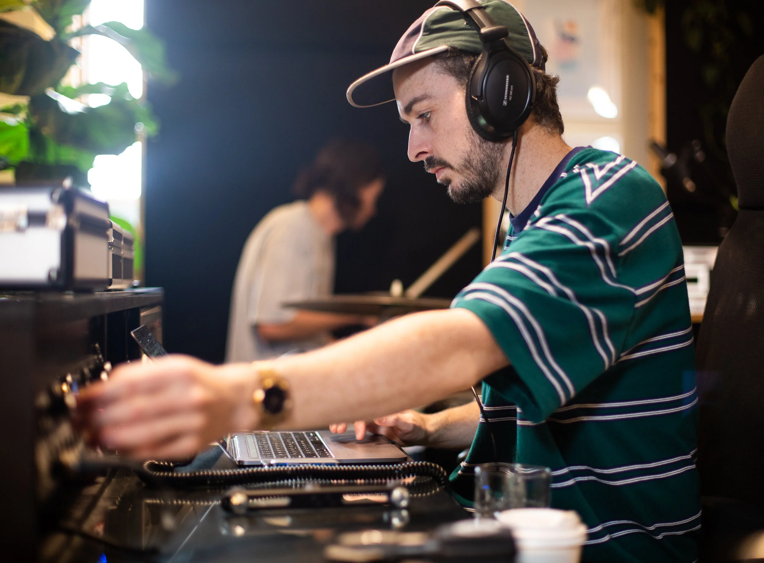 audio engineer jono is operating a recording session with a local band in the studio. he is pictured tracking drums through analogue gear and monitoring the professional band audio through sennheiser headphones. located just near sydney road studios.