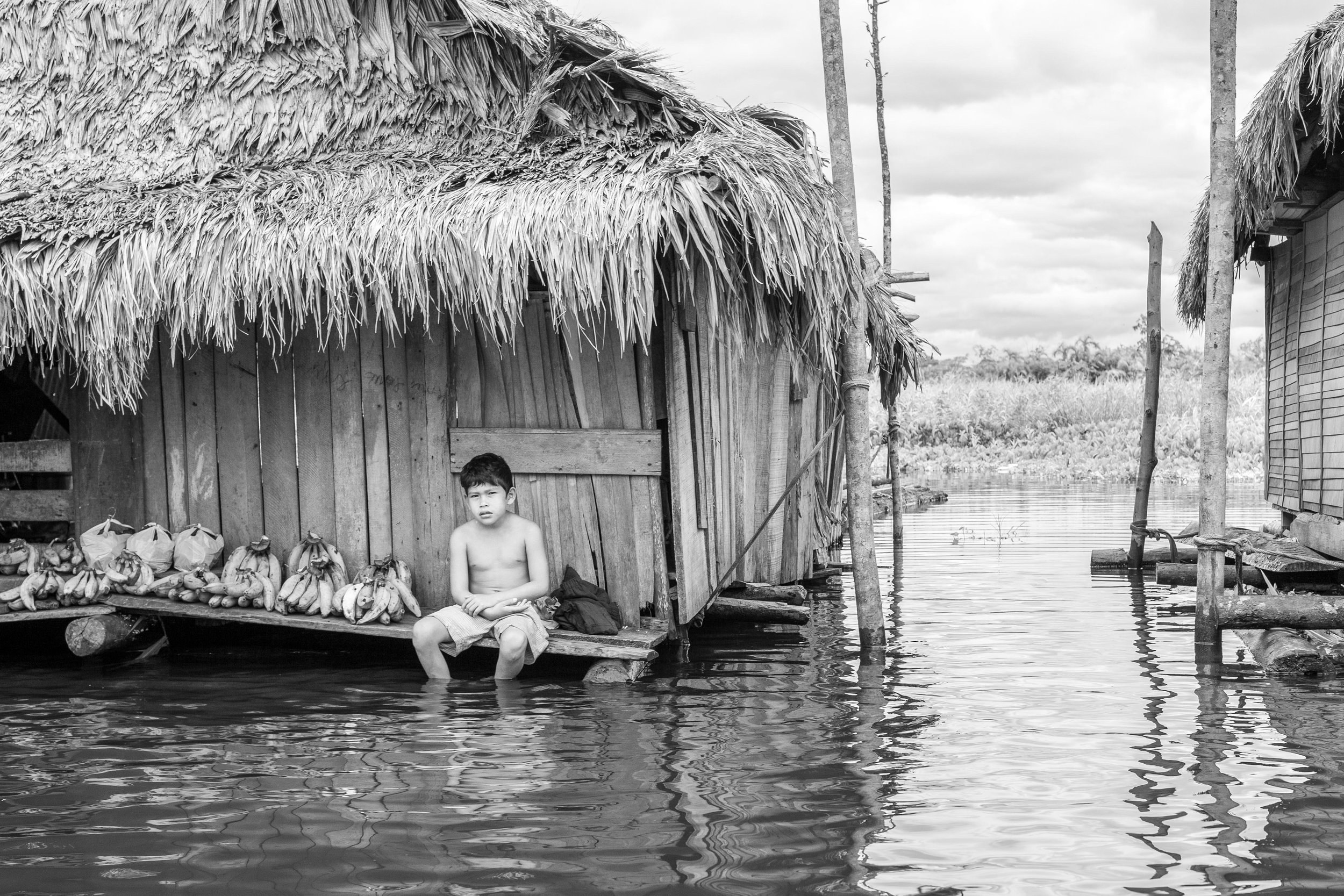 A young boy sells bananas in the flooded village of Belen in Iquitos, Peru.