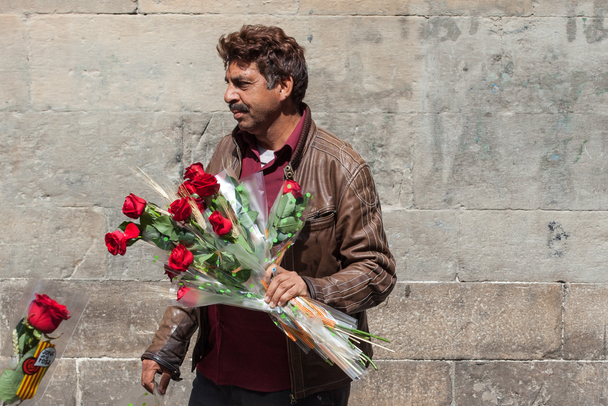 A man sells flowers on the streets of Barcelona.