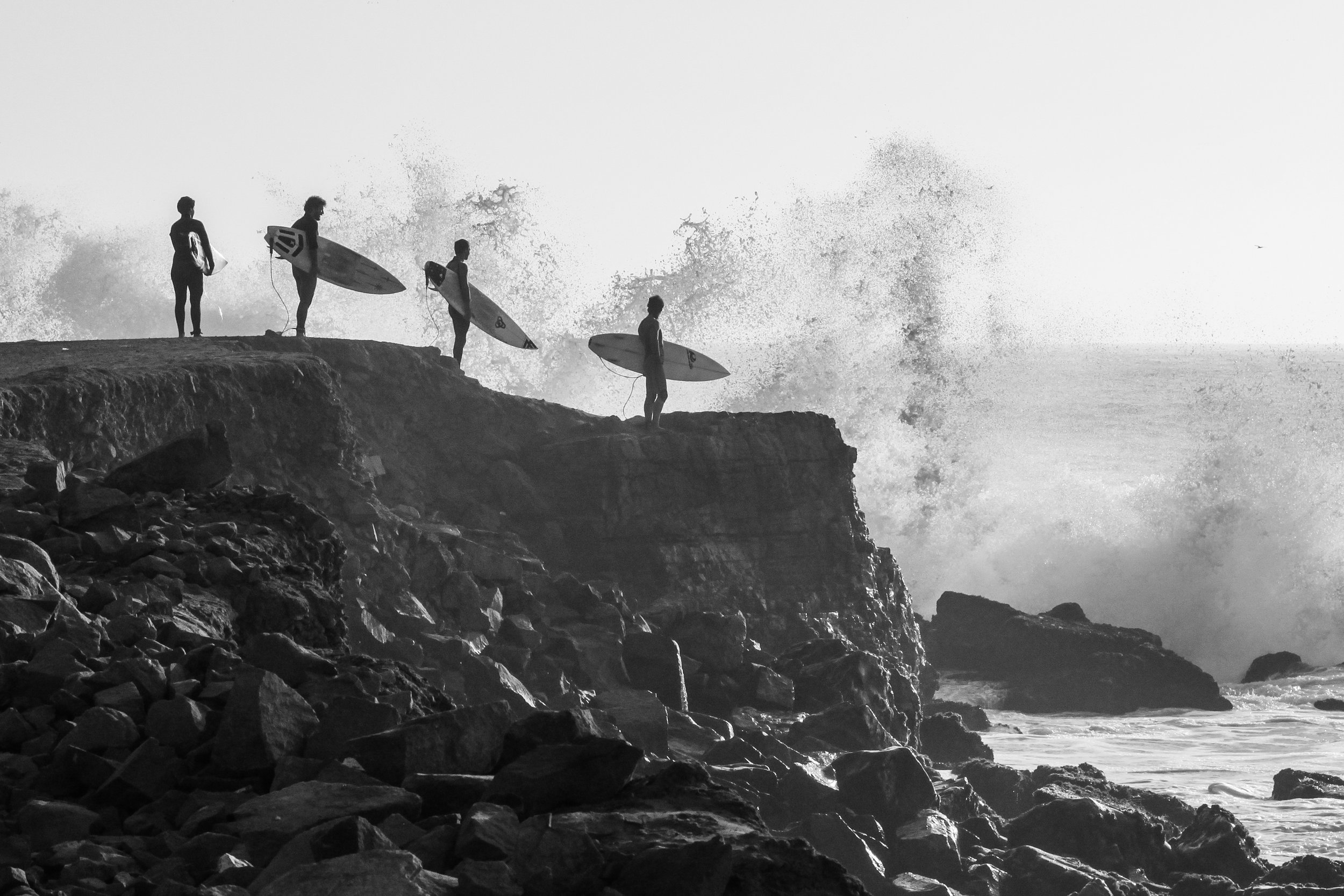 Surfers in Peru in black and white.