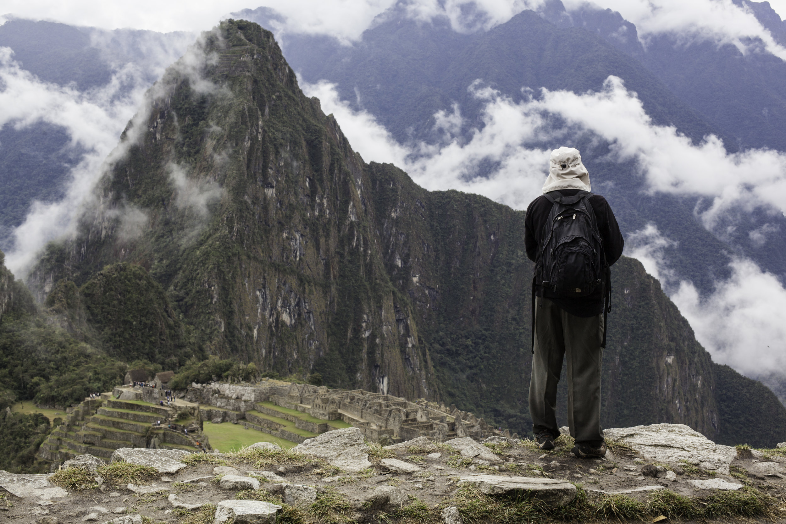 A hiker looks down on the impressive Machu Picchu.