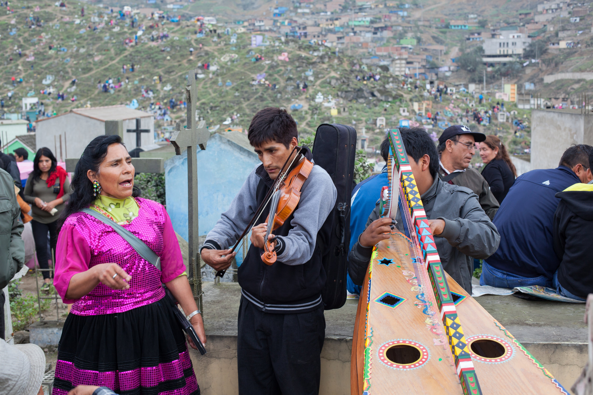 Musicians play for families during Day of the Dead in Lima, Peru.