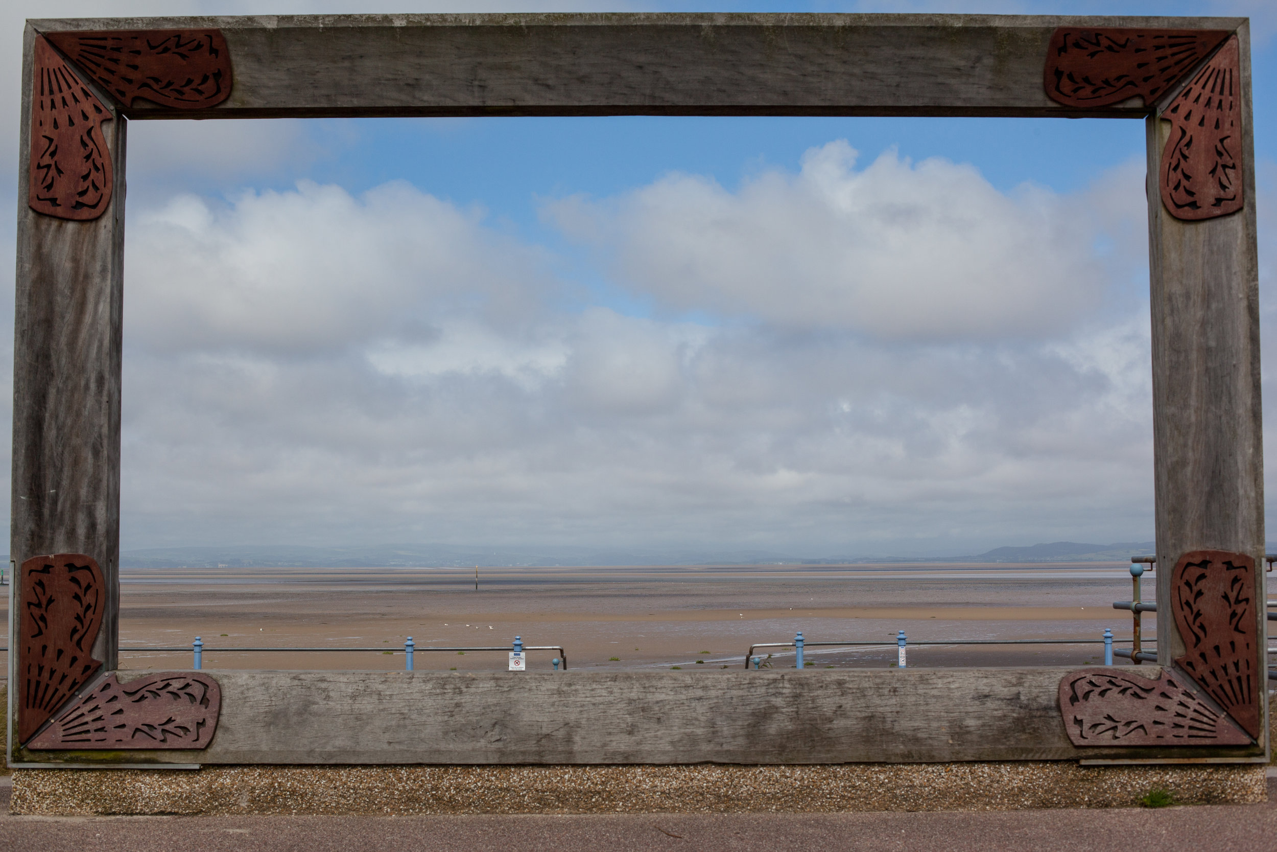 A piece of modern art frames this image looking out to the sea in Morecambe, England.