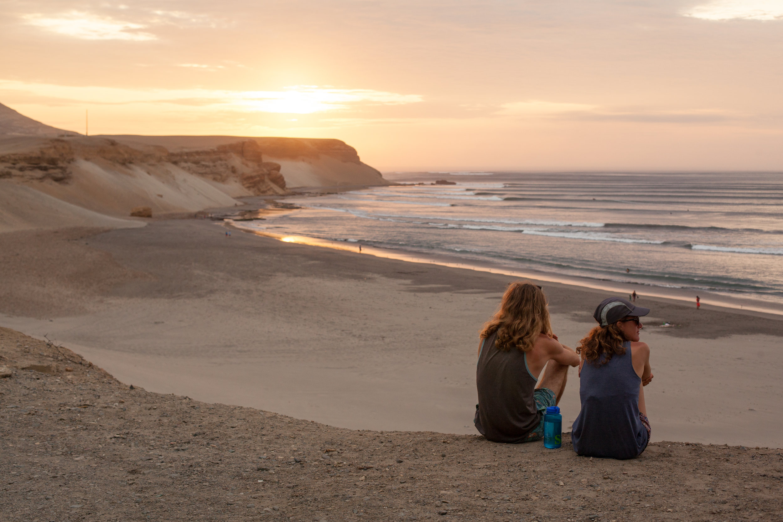 A couple enjoy the sunset over Chicago, the longest wave in the World in the north of Peru.