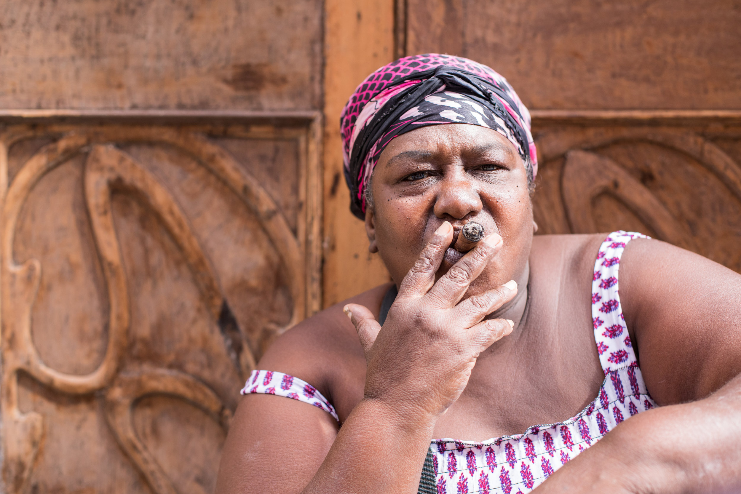 A large Latina women smokes a cigar on the streets of La Habana, Cuba.