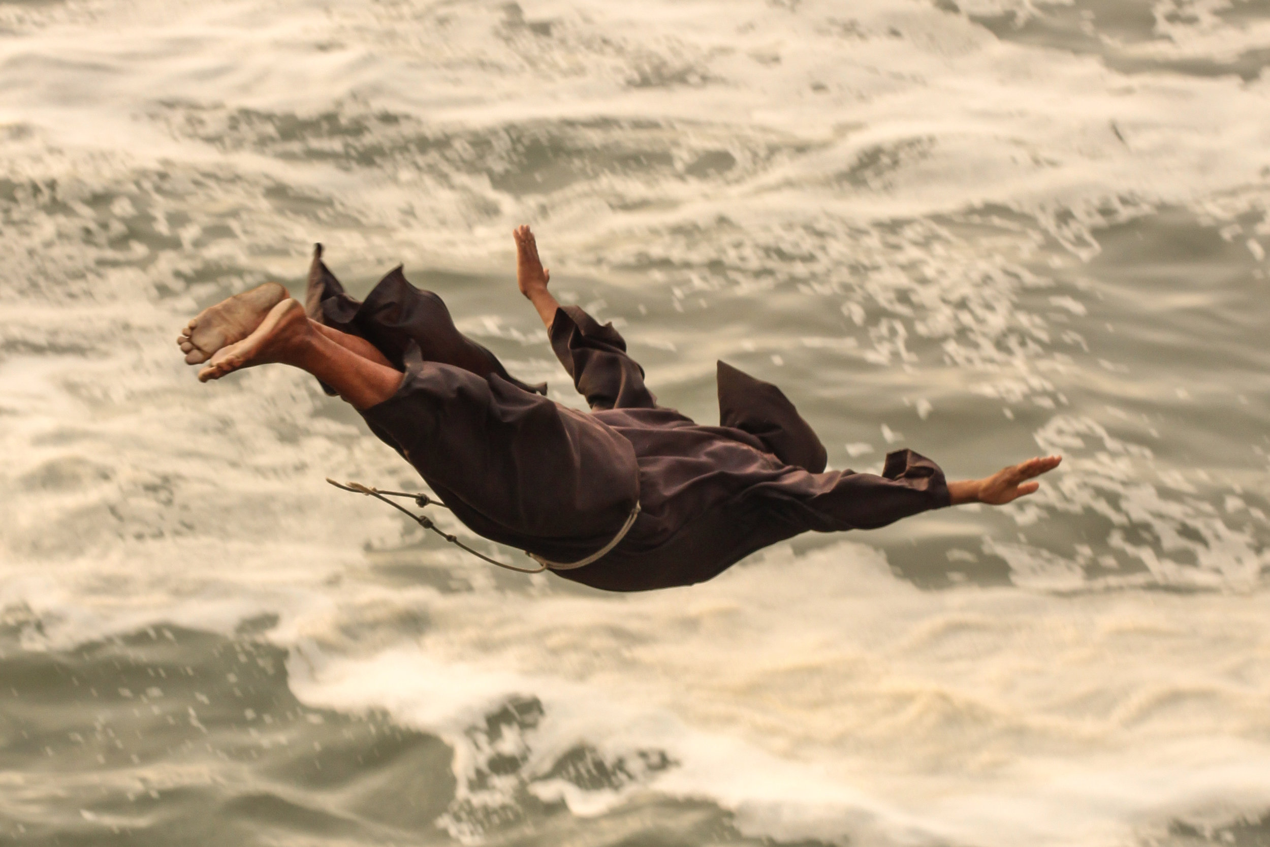 A Monk dives into the water below at El Salto de Fraile, Chorillos, Lima, Peru.