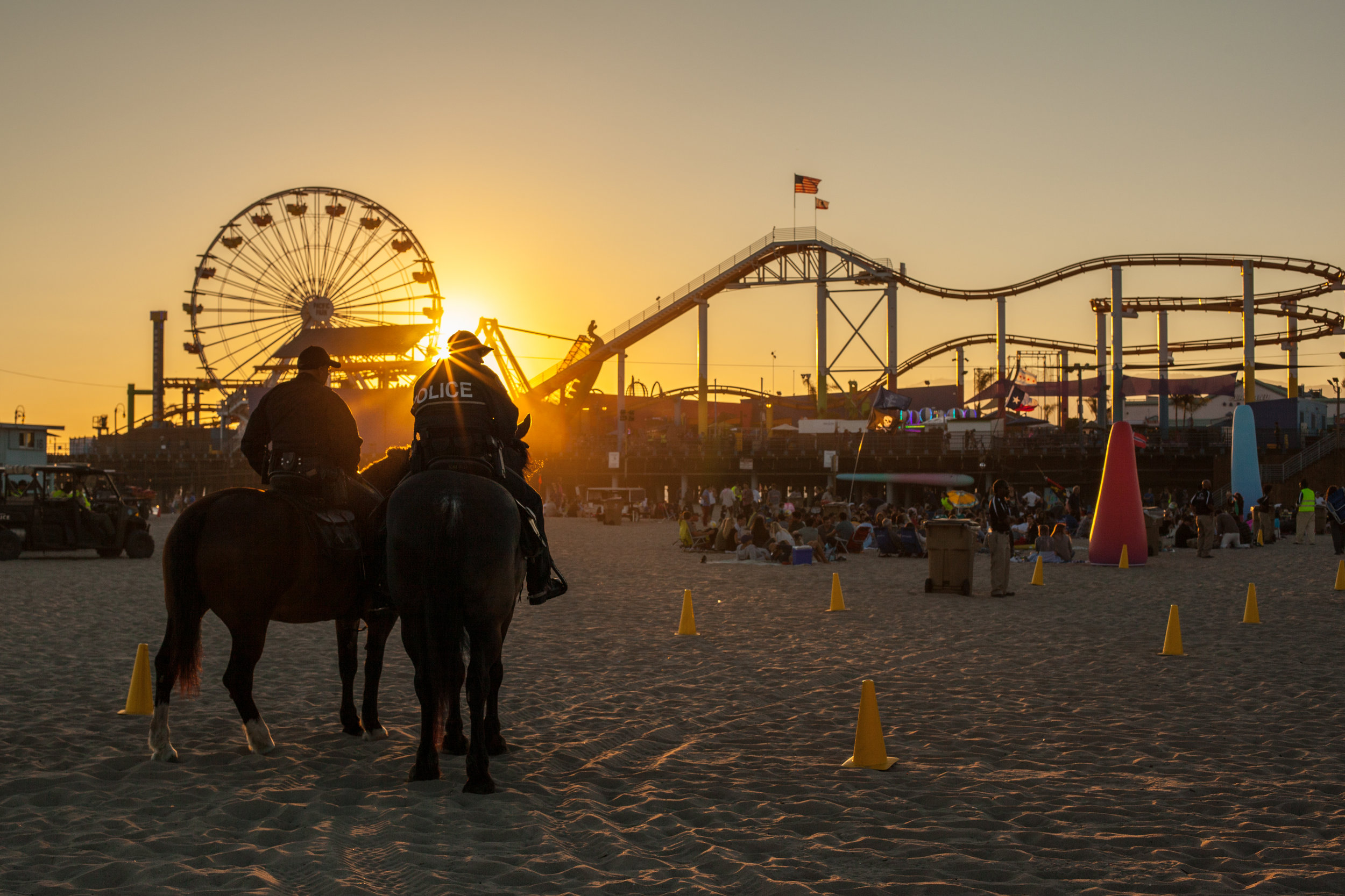 Police on horseback on the beach at Santa Monica with the famous pier in the background.