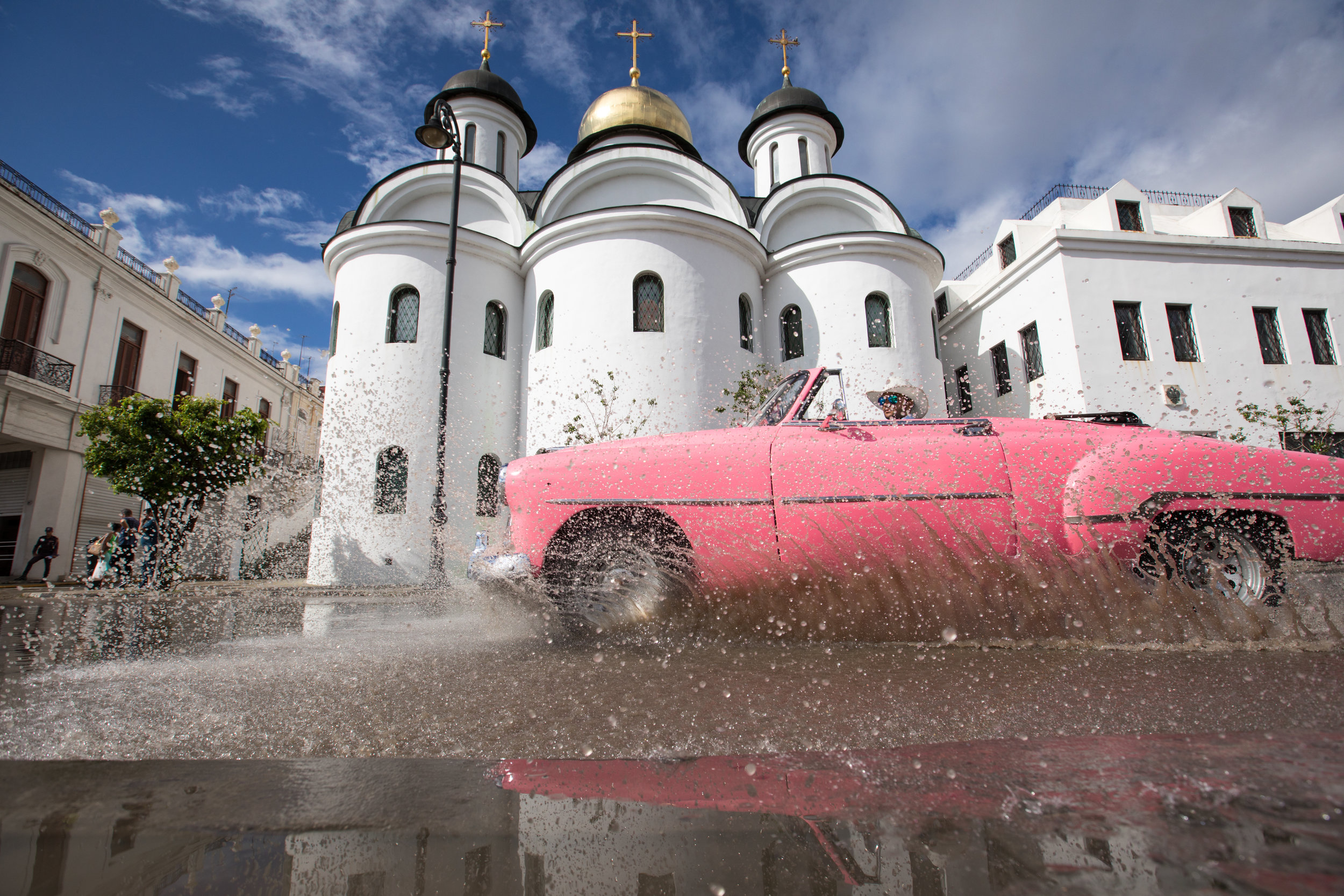 1.  Classic pink car in front of an orthodox church in Havana, the capital of Cuba.