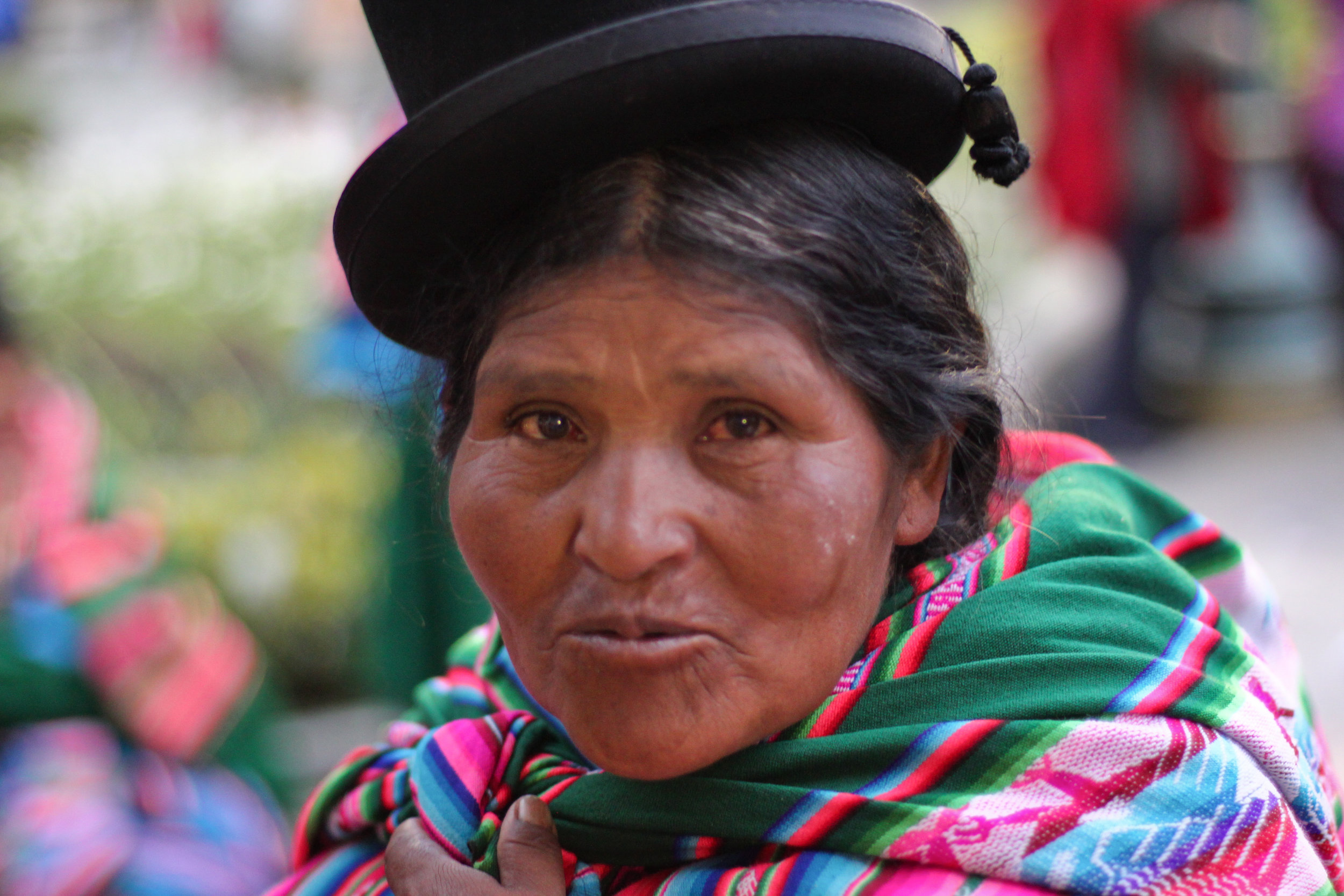 A candid portrait of a traditionally dressed Bolivian woman.