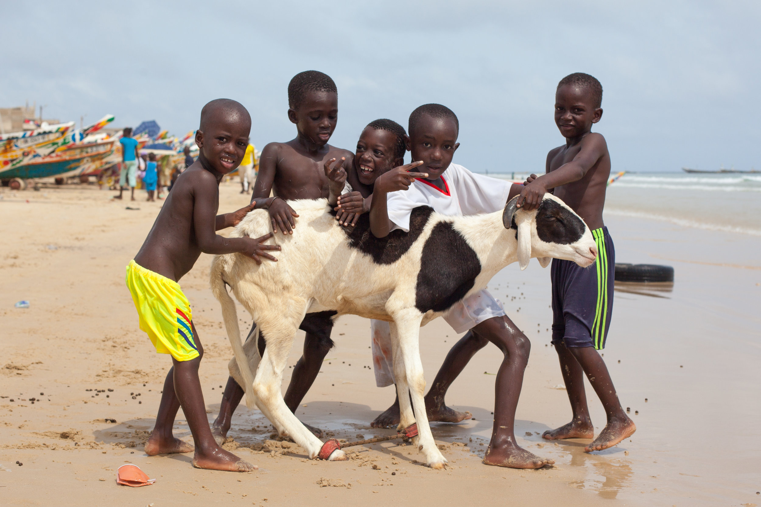 Children pose for a photo with a sheep before the Tabaski Festival on a beach in Dakar, Senegal.