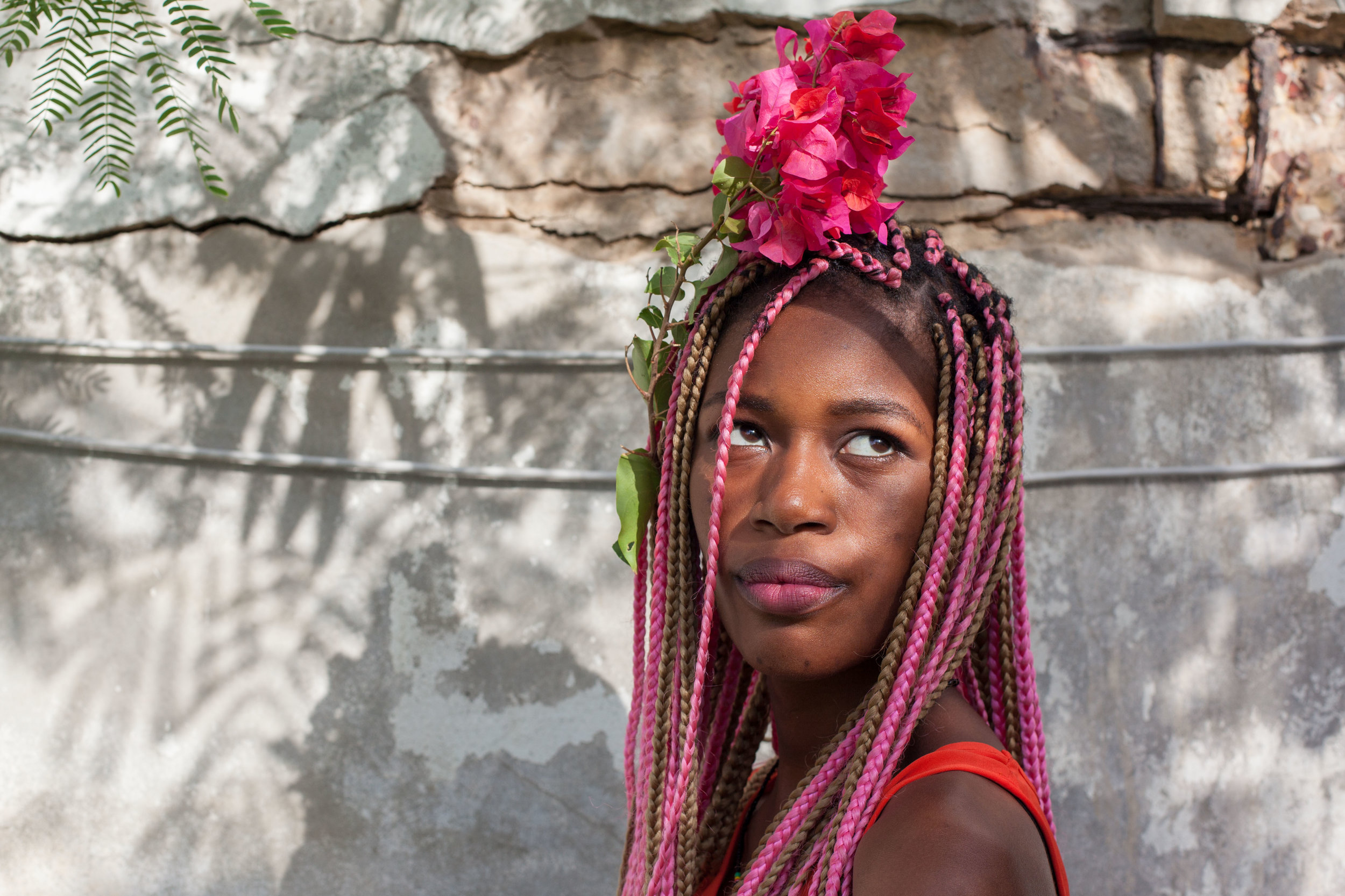A Senegalese woman poses for a photo with flowers in her hair.