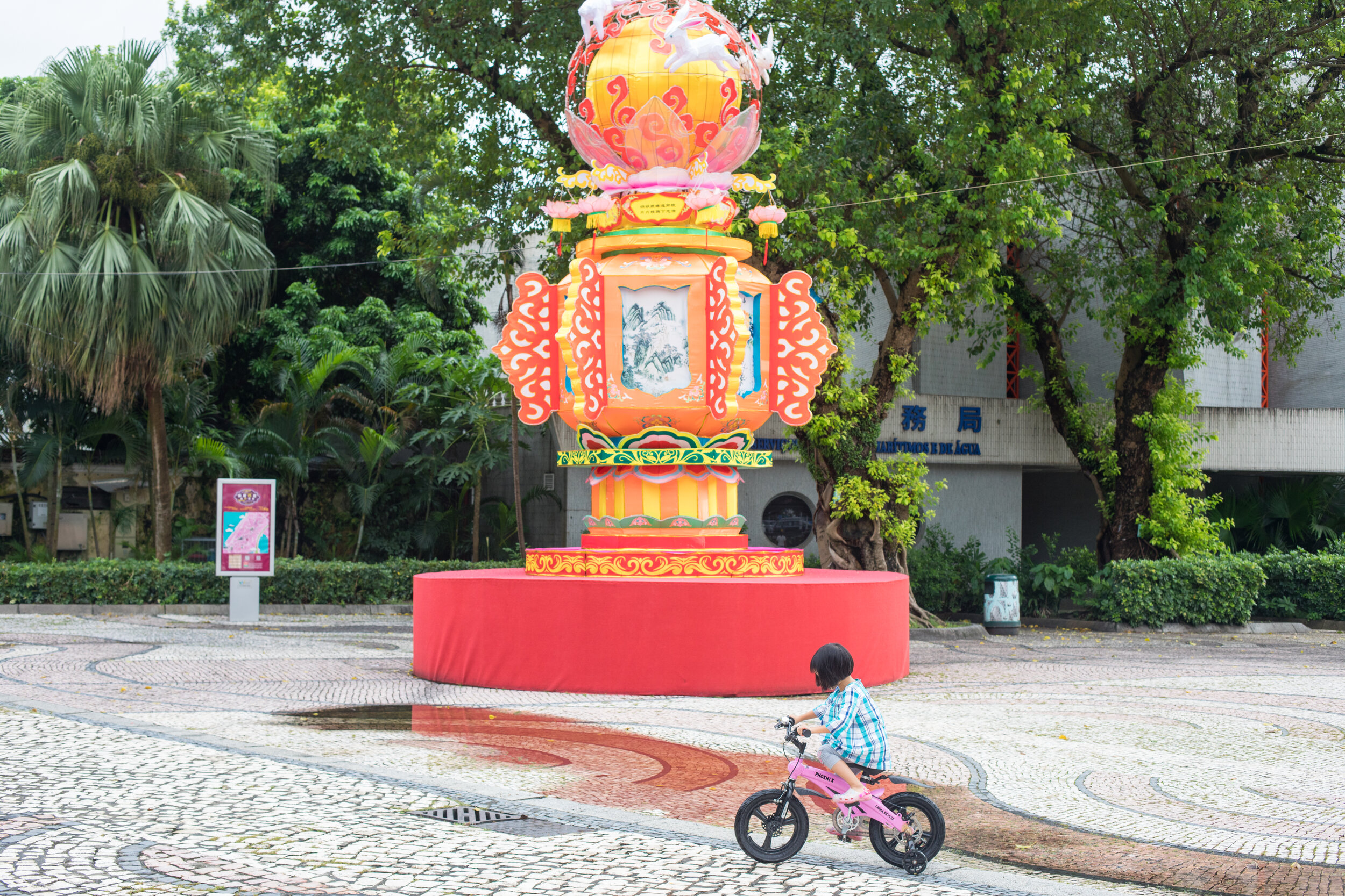 A girl rides her bike outside the A-Ma Temple in Macau.