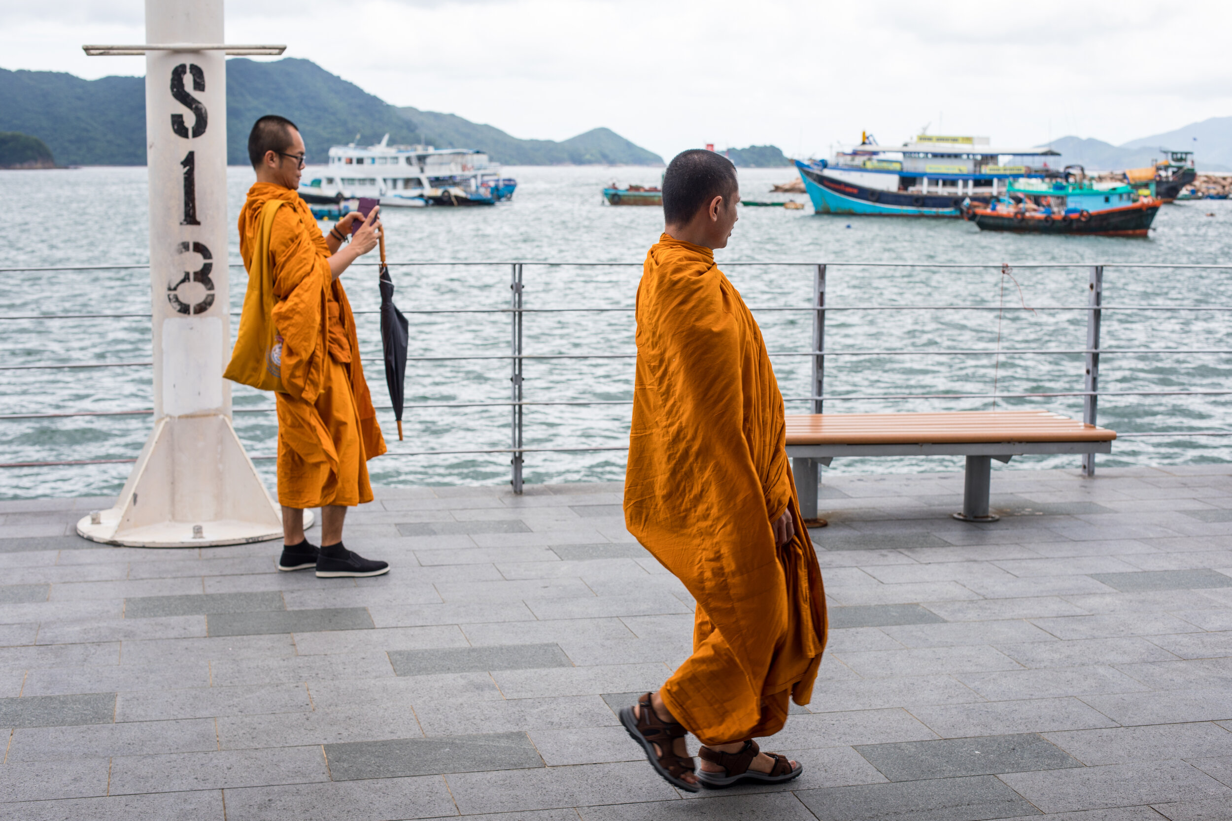 Two young Buddhist monks by the harbour in Hong kong.