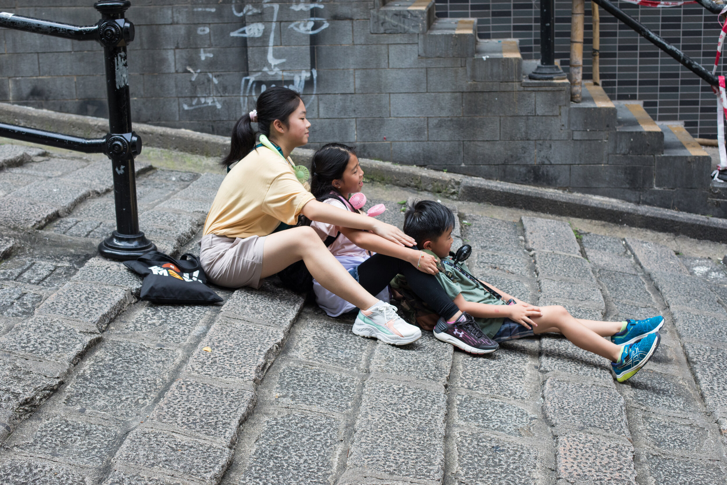 Siblings pose for a family photo in a street on Hong Kong Island.