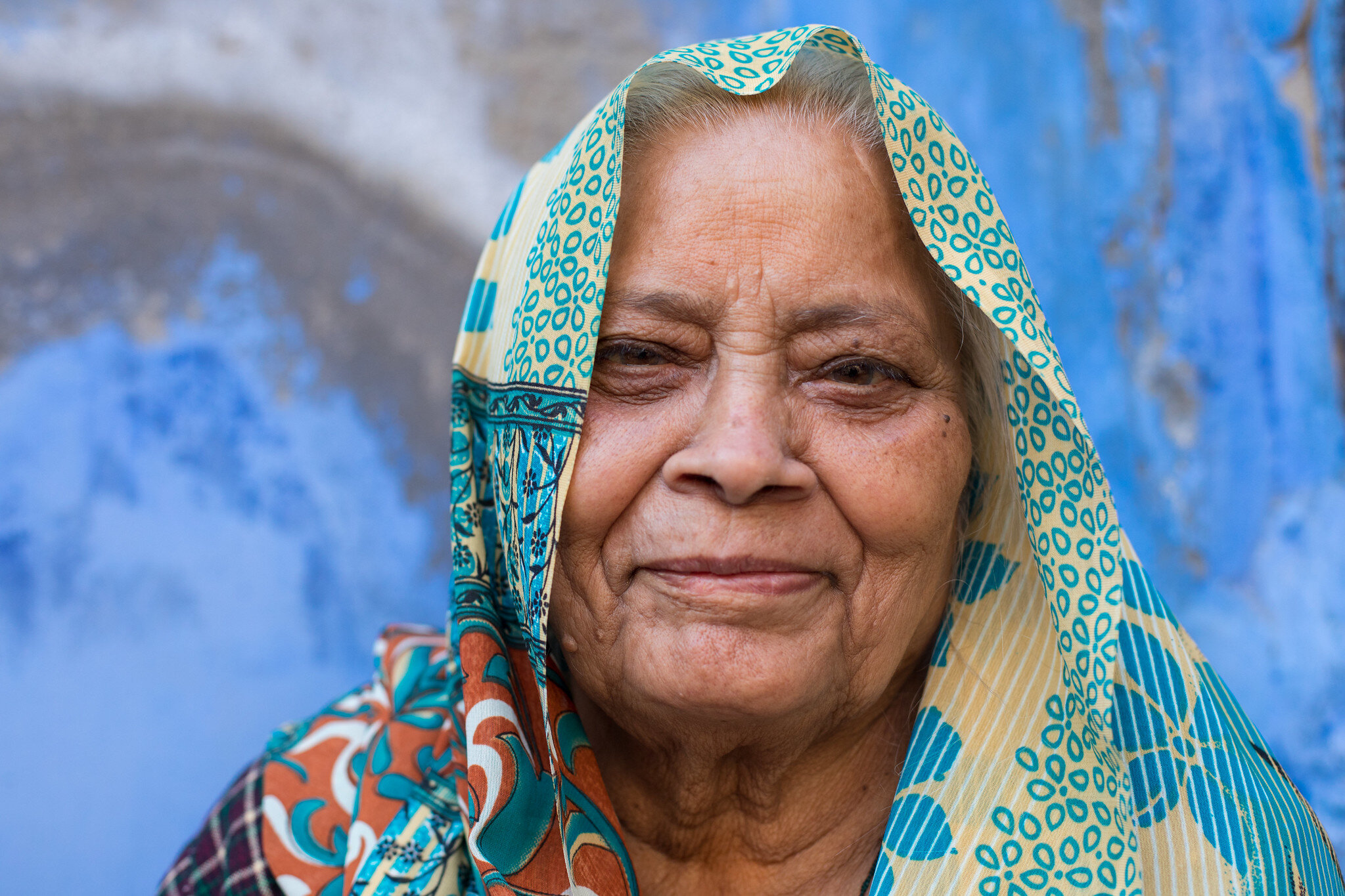 A natural light portrait of a woman outside her home in the  Blue City of Jodhpur, Rajasthan.