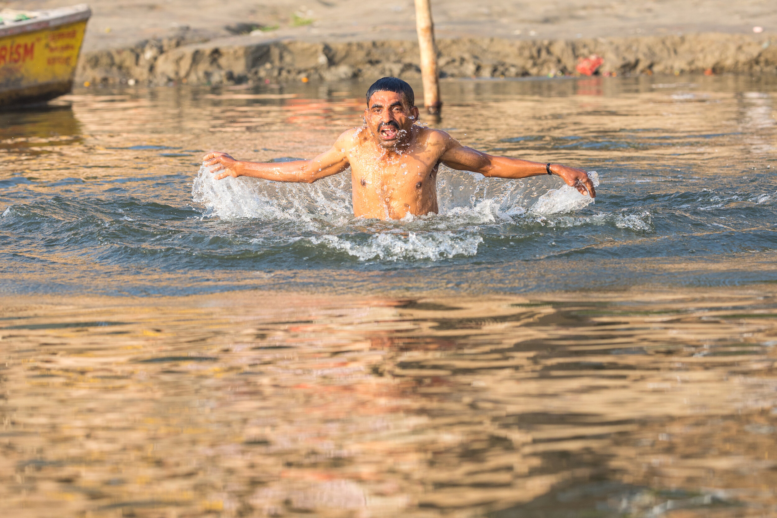 A man takes an early morning swim in the River Ganges.